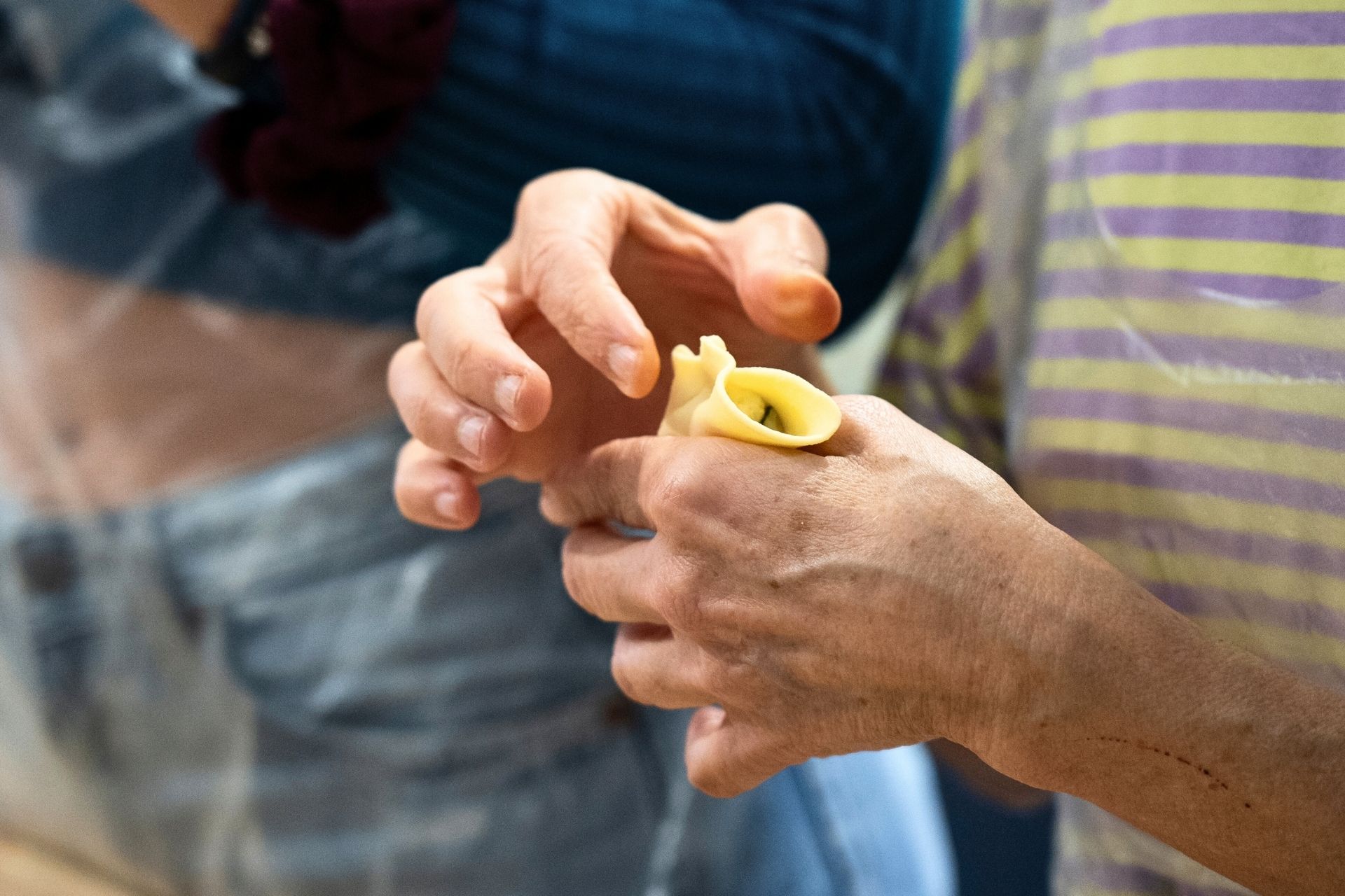 Una persona sta preparando un piatto di pasta fresca in un laboratorio di cucina nel centro di Alghero