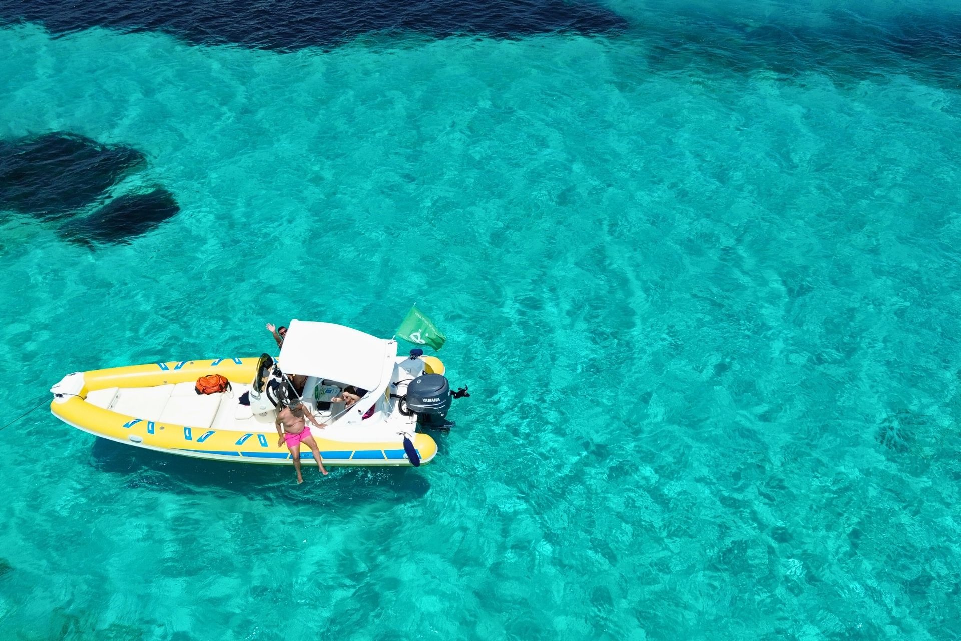 Dinghy with which people relax on board in the crystal clear sea of Asinara