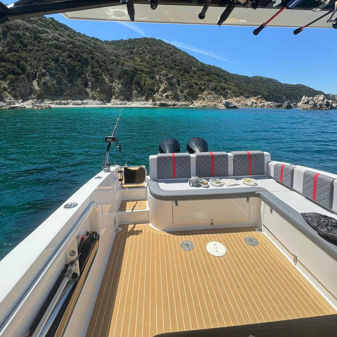 Privates Boot, das im kristallklaren Meer entlang der Costa Smeralda geparkt ist