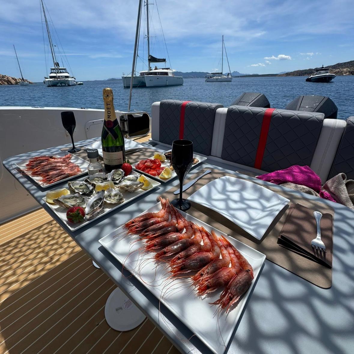Esstisch auf einem Boot mit Meerblick, Fischgerichten und Champagner.