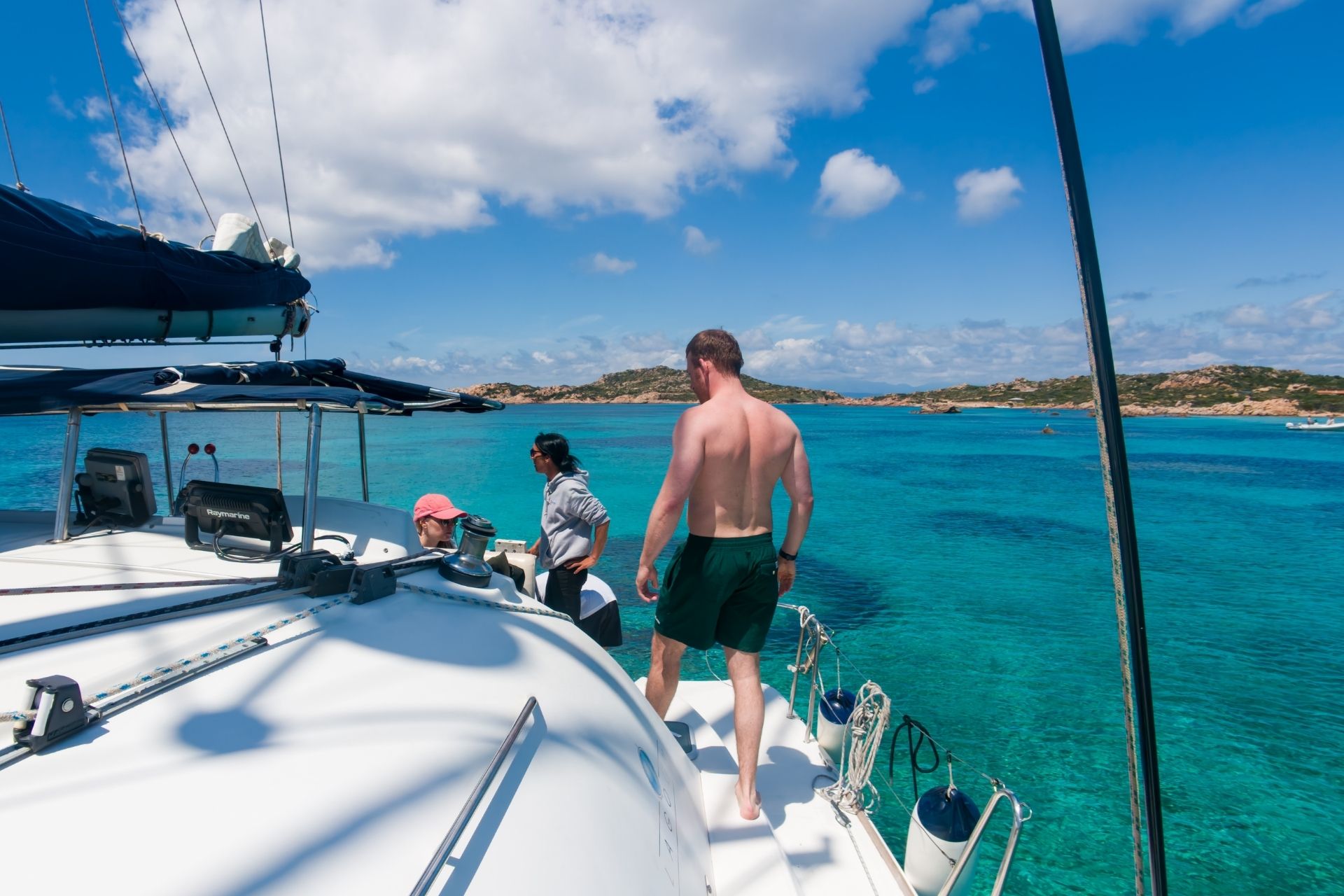 People on a catamaran sailing between the islands of the La Maddalena archipelago.