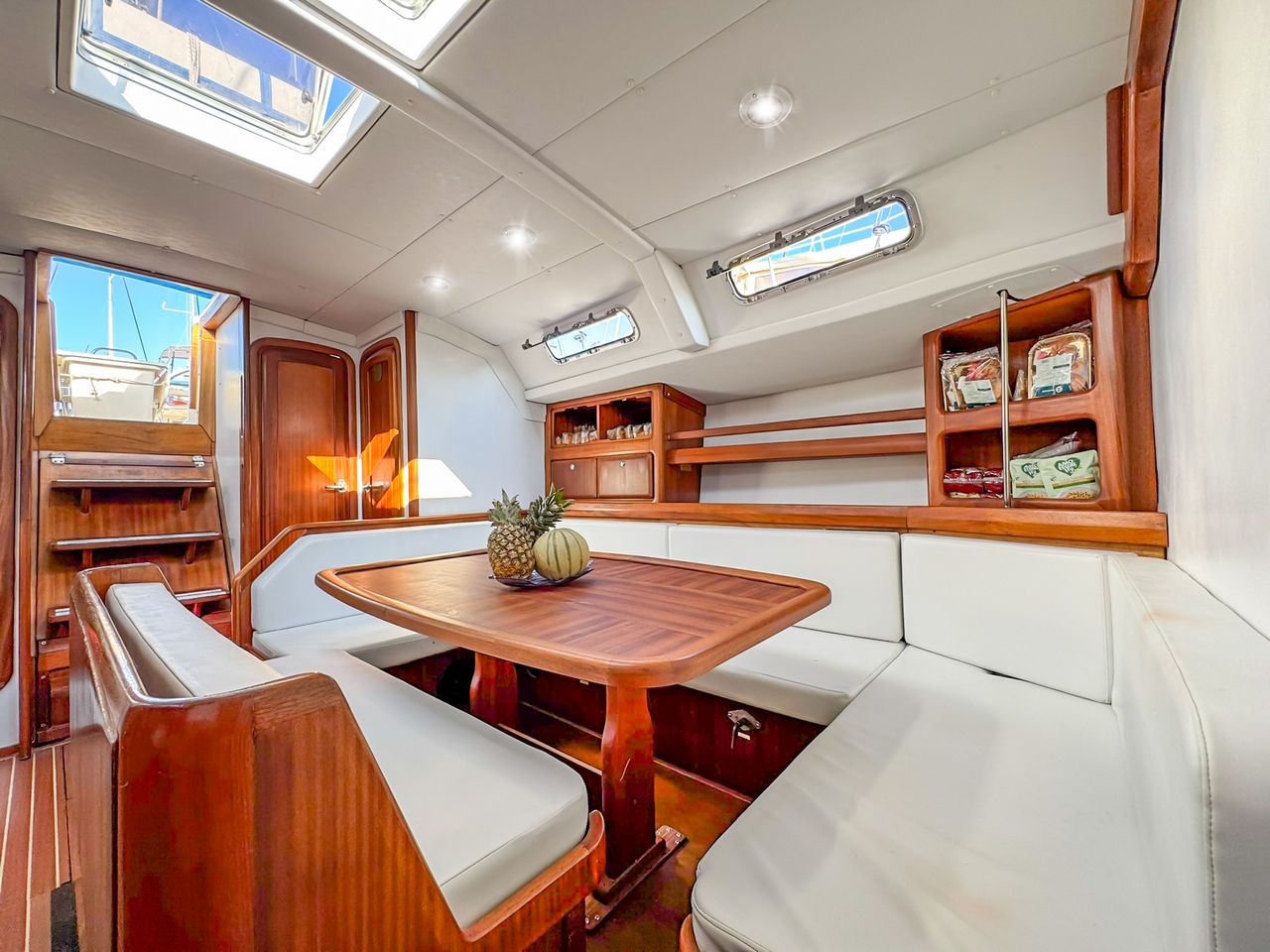 Intérieur du voilier avec coussins et table en Sardaigne