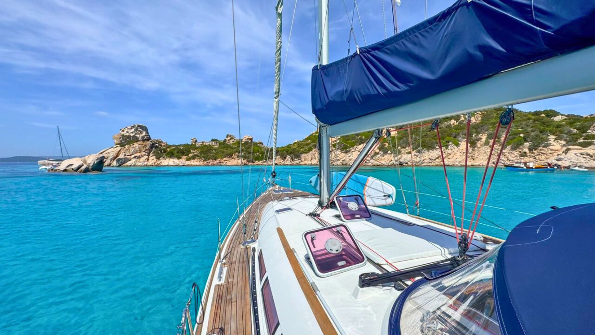 Un barco histórico de los años 60 navega en aguas cristalinas, hace paradas en bahías espectaculares, visitas a Figarolo y Cala Moresca