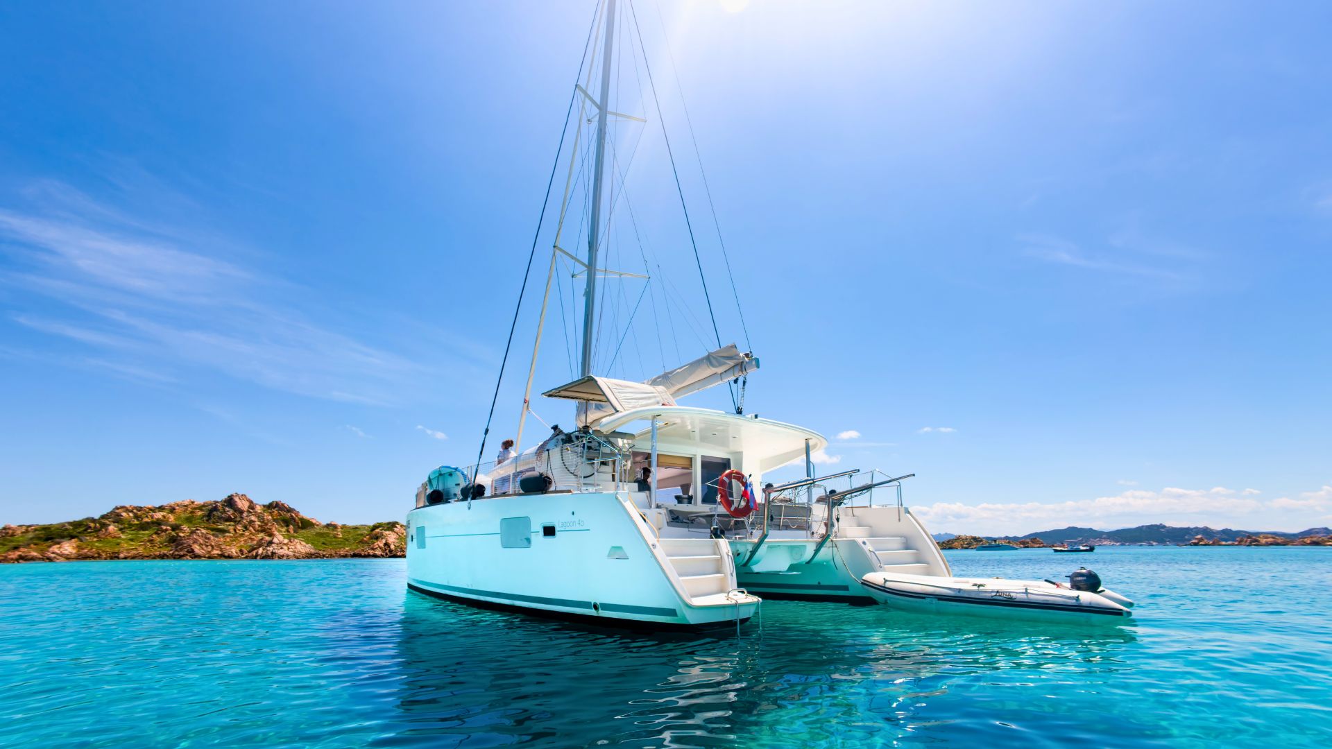 Un catamarán amarrado en aguas cristalinas con una isla al fondo