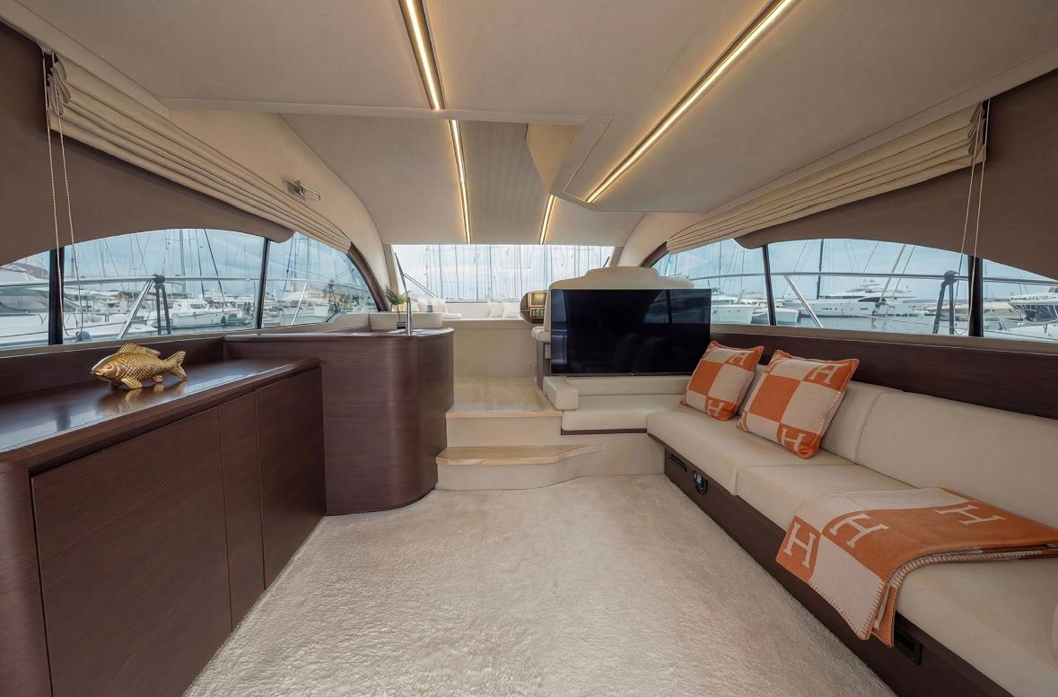 Innenraum einer luxuriösen Privatyacht mit Sofas, Tisch und TV
