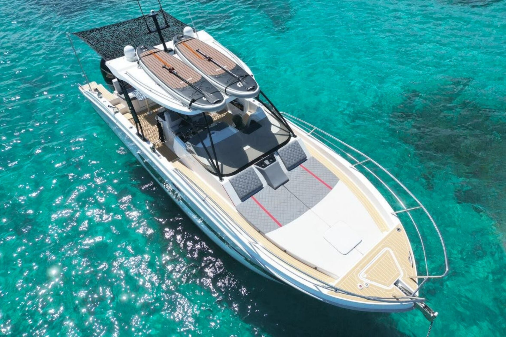 Ein privates Boot segelt durch das kristallklare Wasser Nordsardiniens