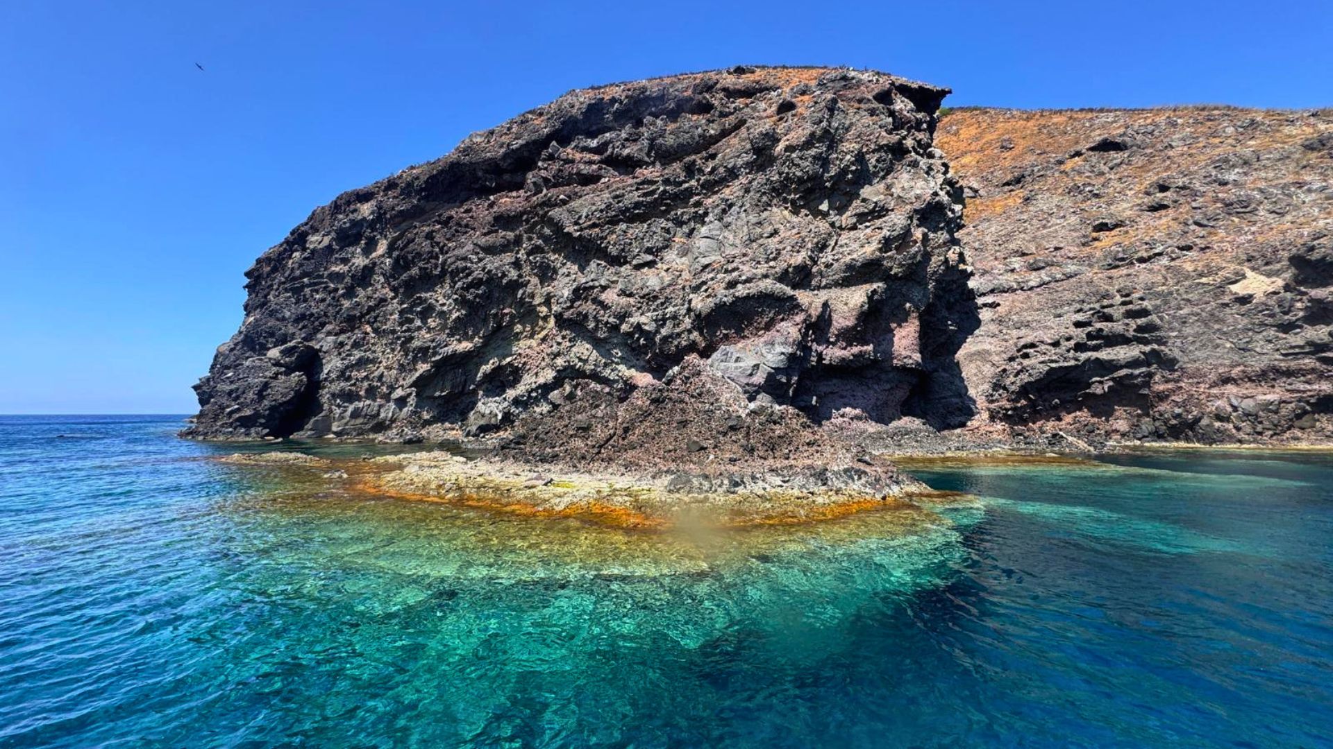 Image of a rocky island with clear waters and pristine backdrops