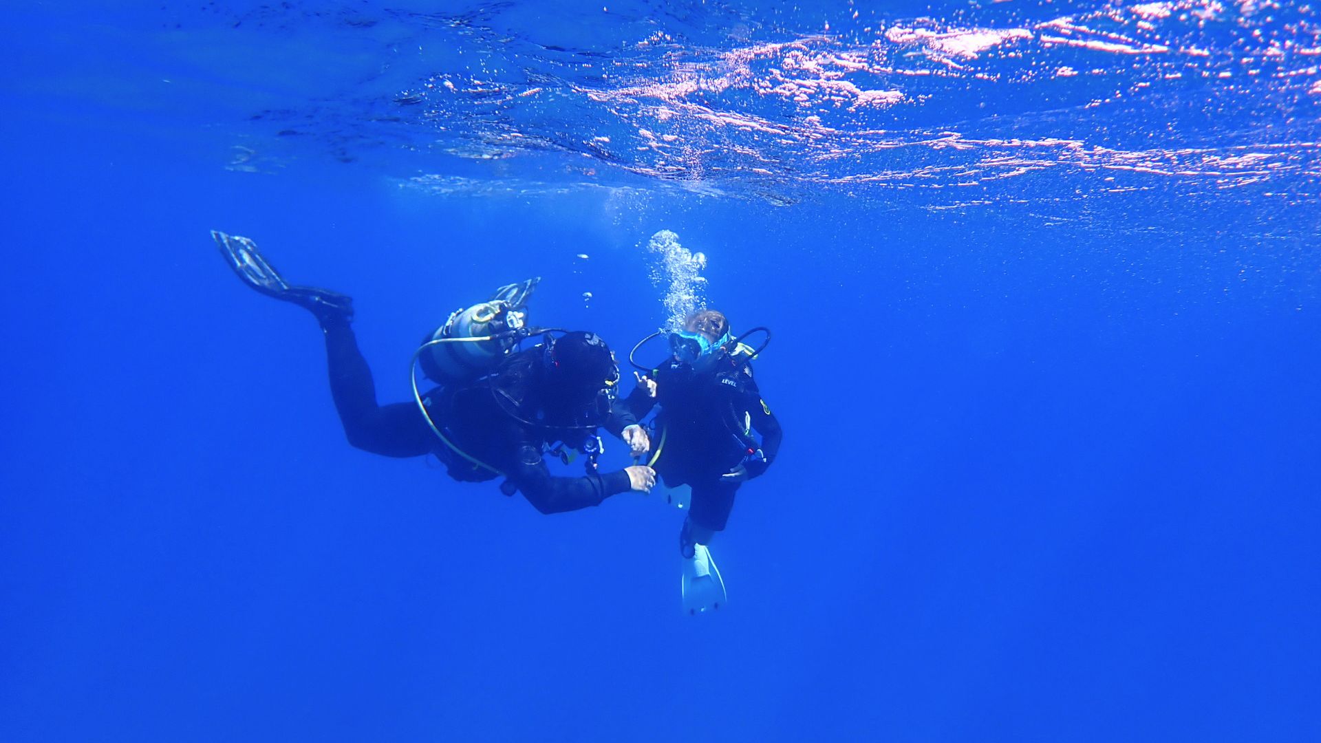 Two divers diving in the clear waters of Sant'Antioco, southern Sardinia