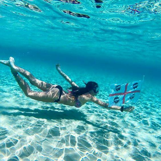 Une fille nage sous l'eau, entourée d'une mer d'un bleu limpide.