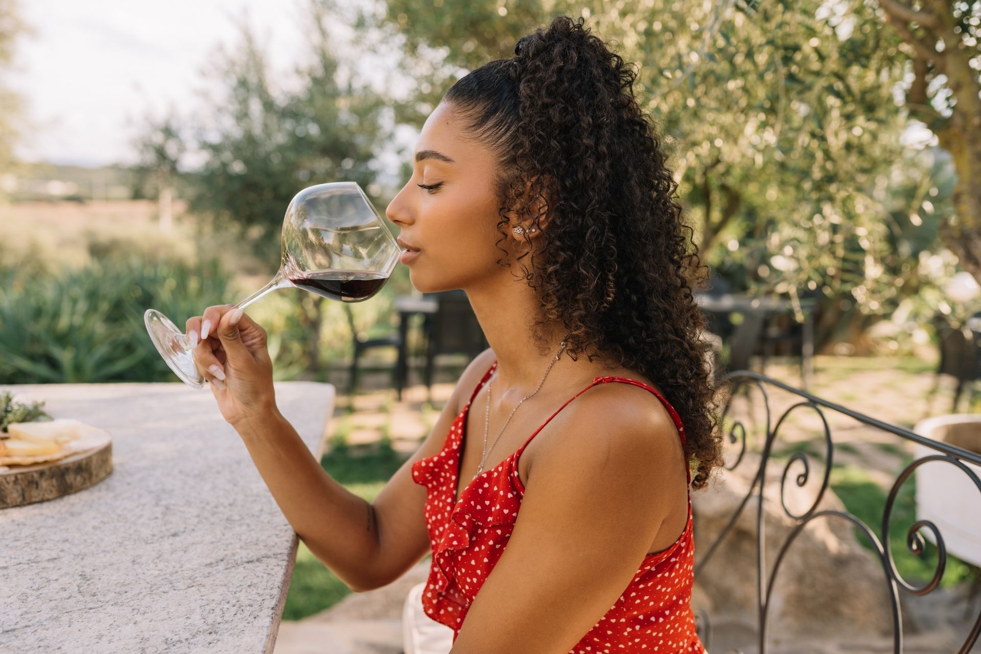 Niña prueba vino en un viñedo cerca de Olbia