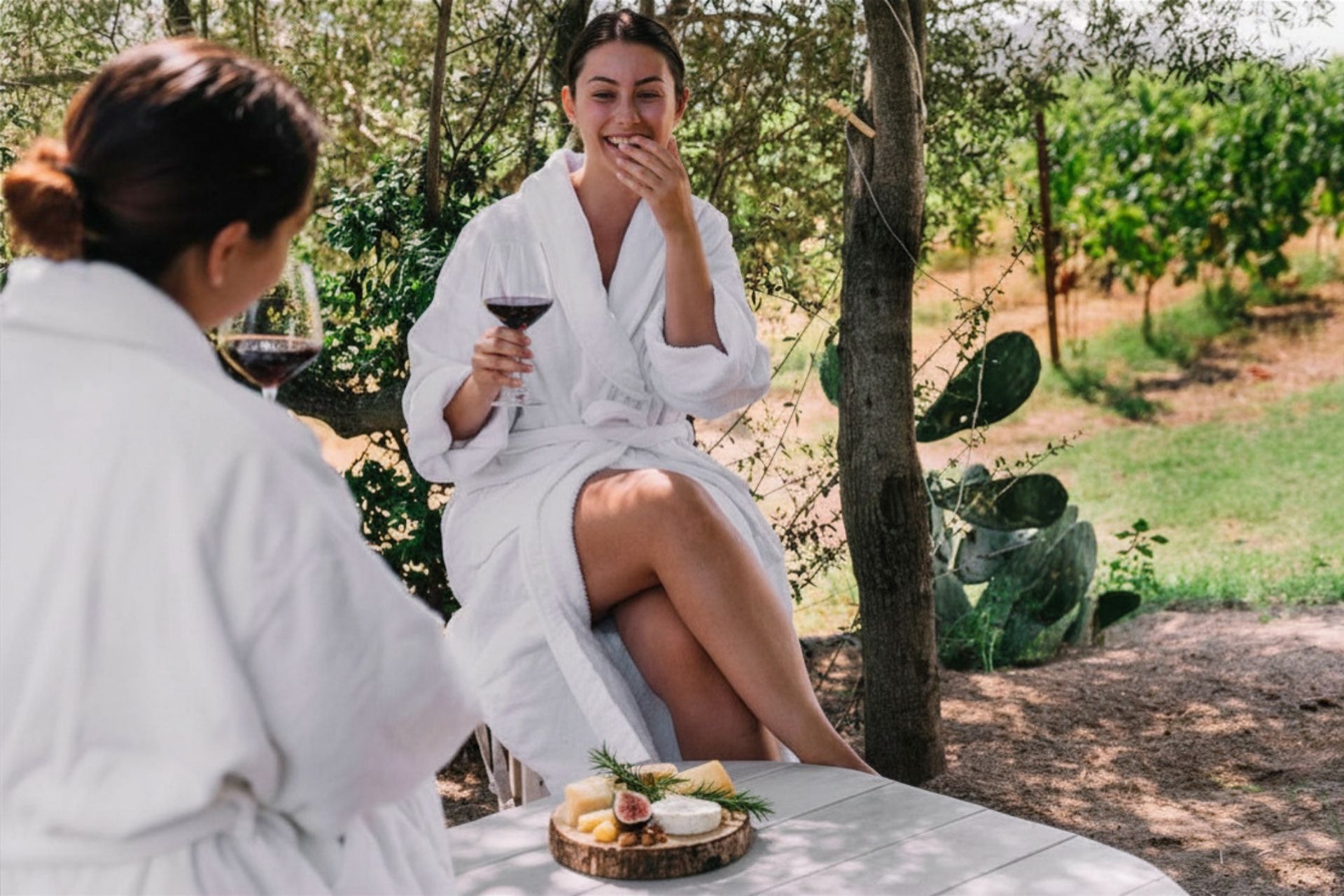 Due ragazze si rilassano nella vigna e gustano prodotti tipici locali