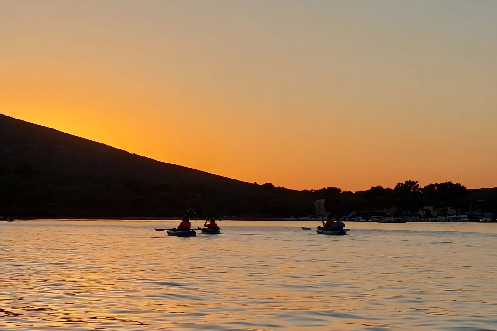 Parada en kayak durante el recorrido en el parque de Porto Conte al atardecer