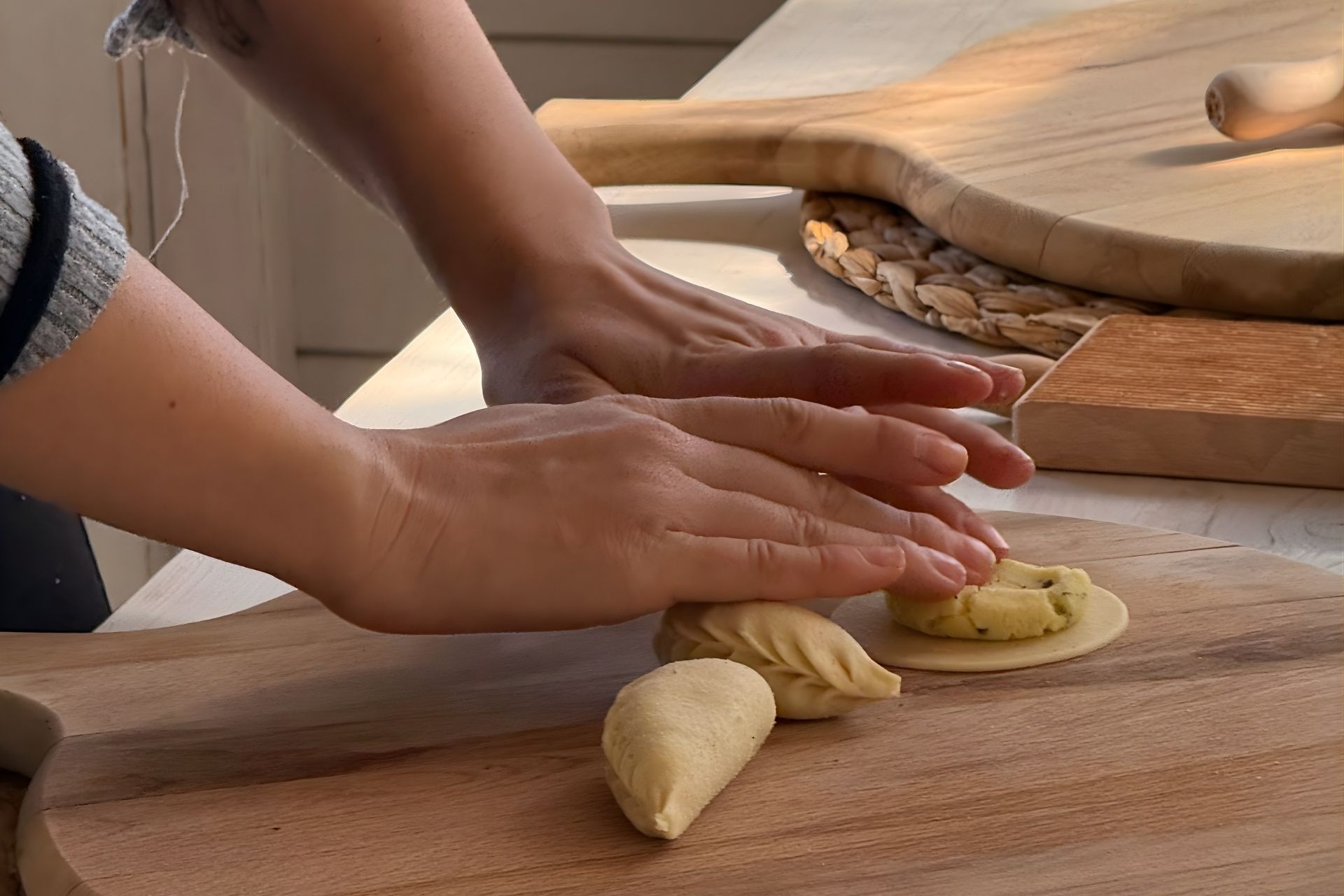 Una persona prepara pasta fresca a Olbia, circondata da altri ingredienti e utensili da cucina