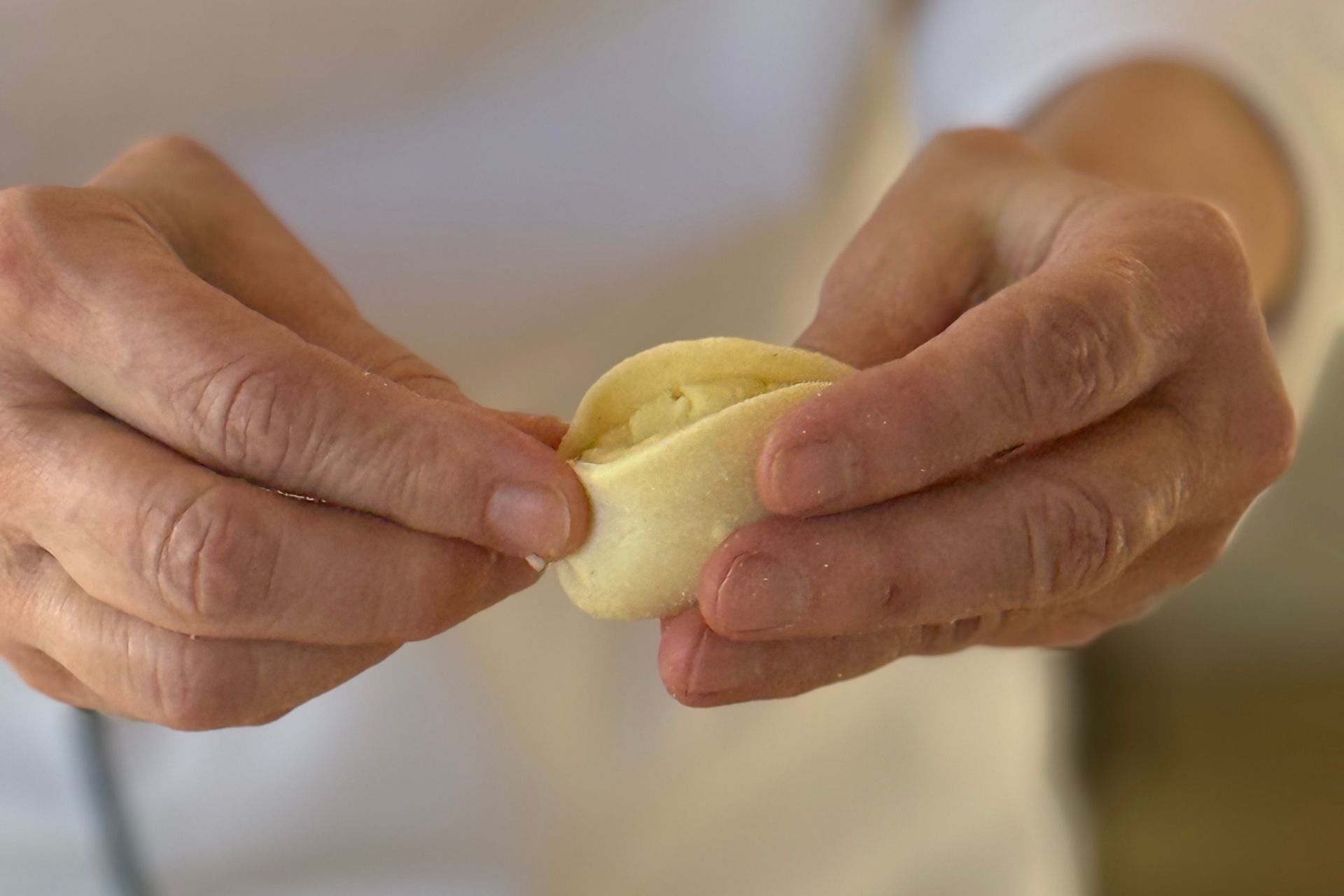 Una persona prepara pasta fresca a mano durante un laboratorio di pasta a Olbia.