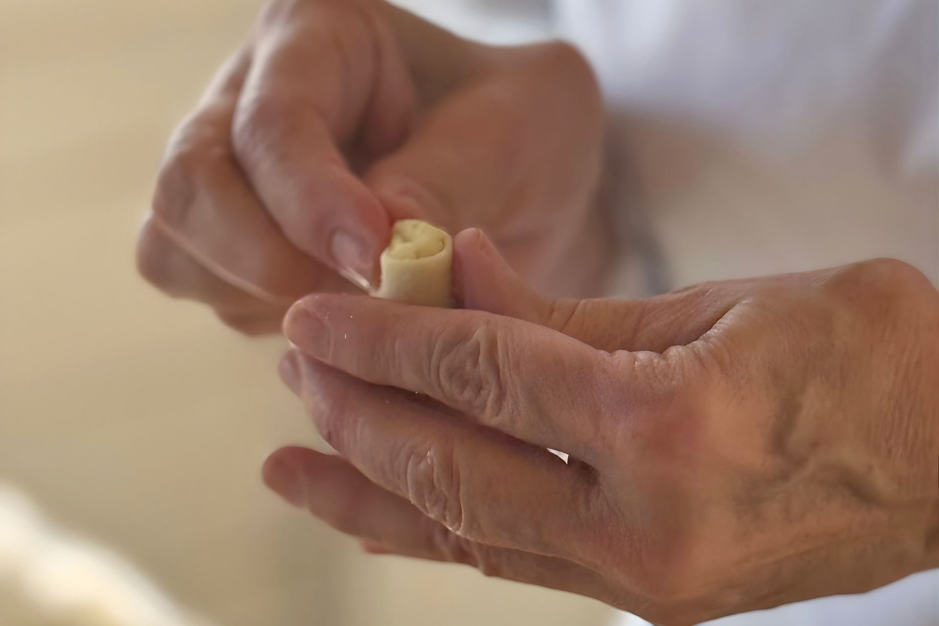 Una persona realizza dei culurgiones a mano durante il laboratorio a Olbia