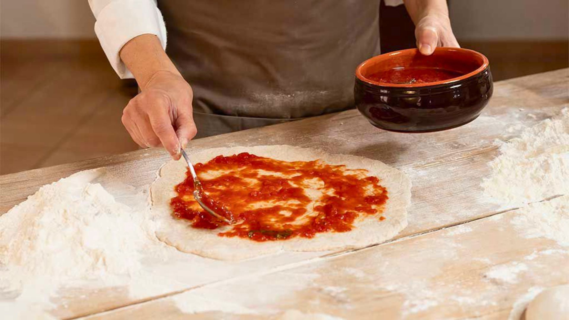 Donna prepara la pizza durante la cooking class a Orosei