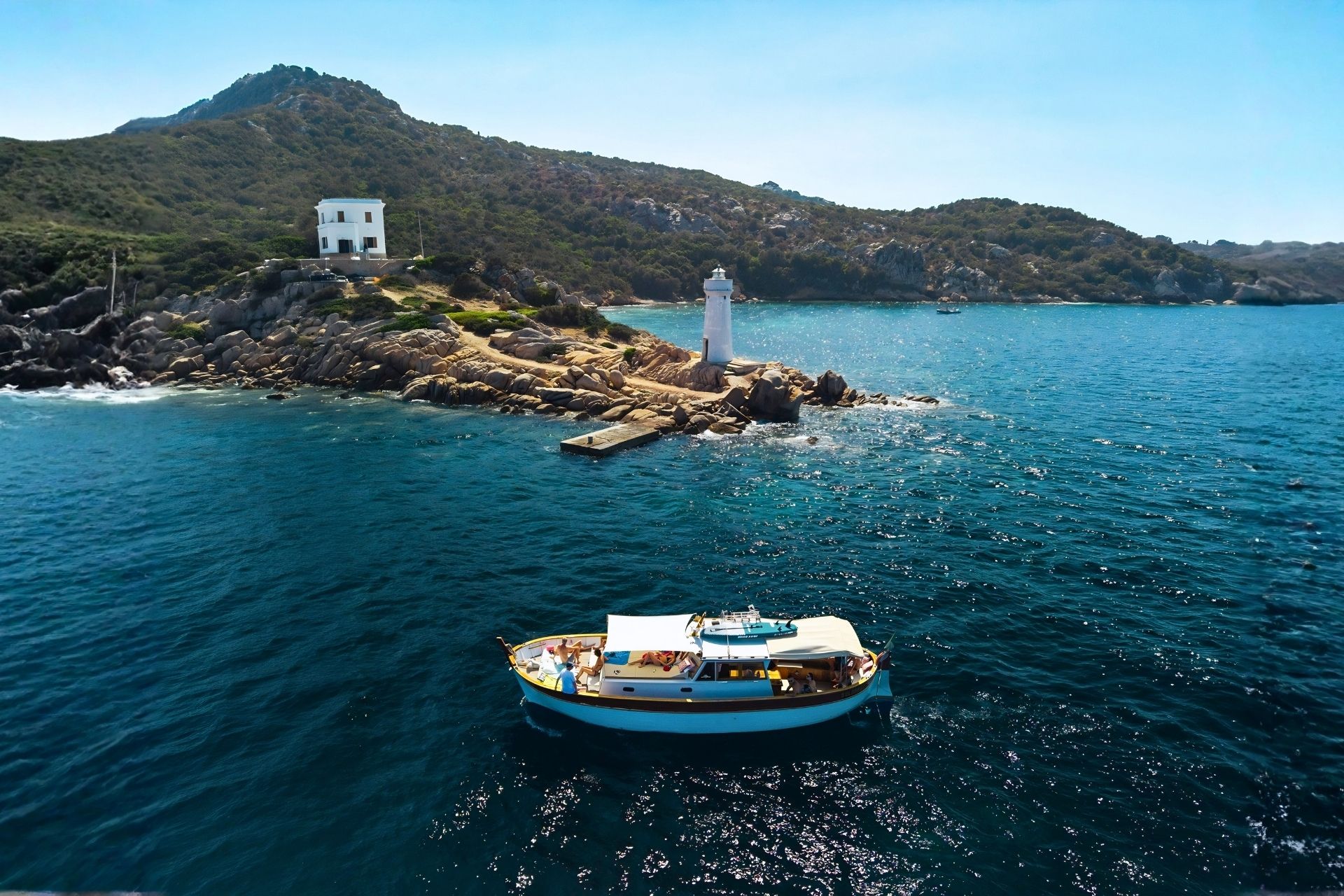 Vintage boat sailing between the islands of Caprera, Budelli and Spargi with passengers on board enjoying the sun and crystal clear sea