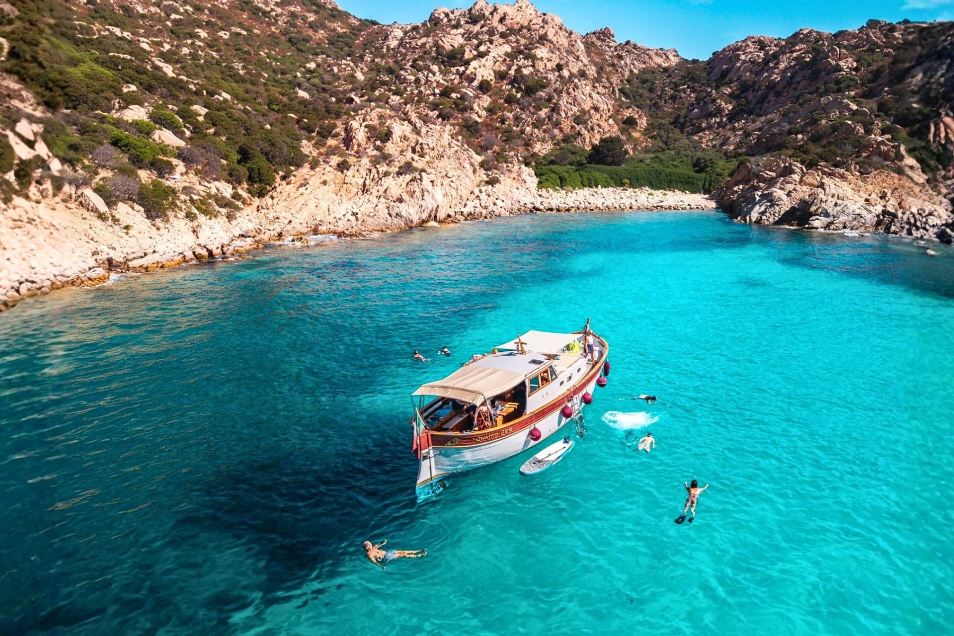 a group of people swim and have fun in the crystal clear sea of the La Maddalena archipelago