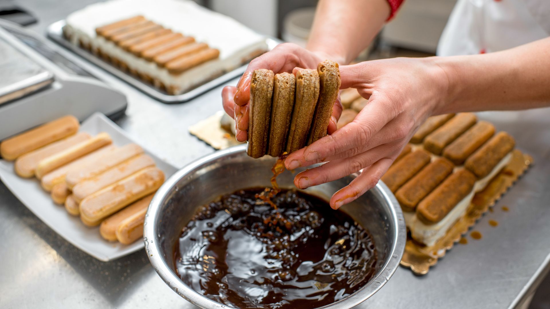 A person makes ladyfinger cookies for making tiramisu