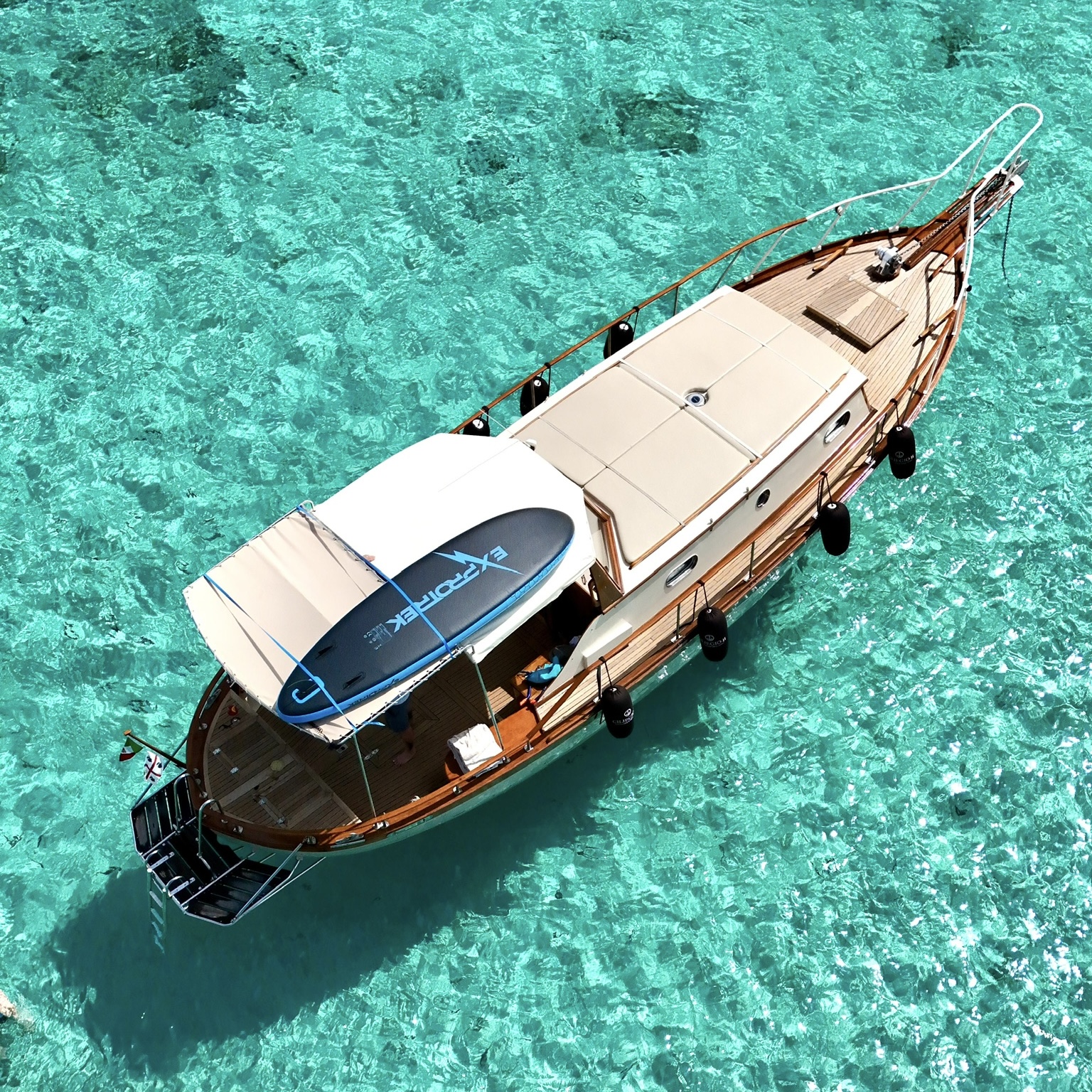 Ein elegantes Holzboot segelt zwischen den Inseln des La Maddalena-Archipels mit Stopps an den Naturpools und dem Pink Beach sowie Mittagessen an Bord mit lokalen Produkten.