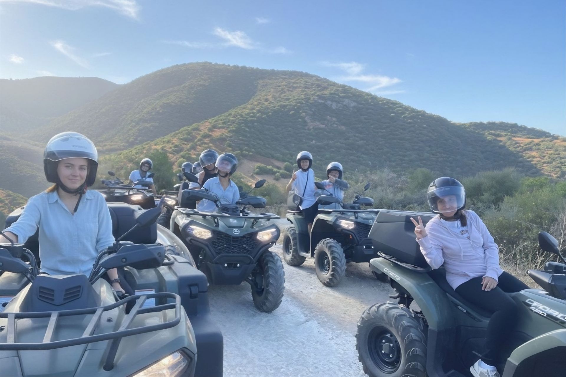 Groupe de personnes sur des quads dans un paysage de terre avec des montagnes en arrière-plan