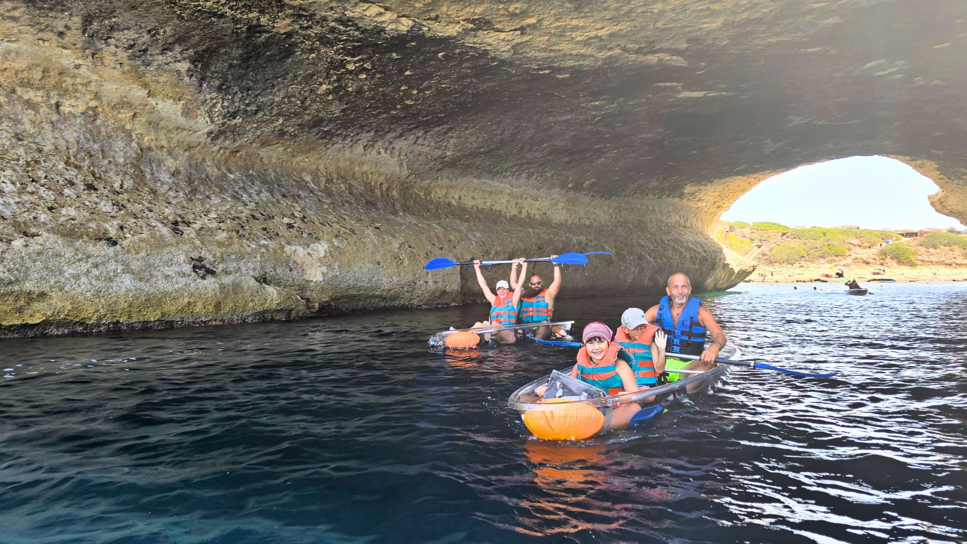Gruppo di persone in kayak trasparente che pagaiano lungo la costa occidentale della Sardegna, vicino ad Oristano