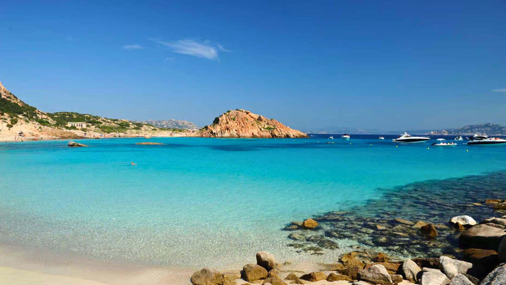 Photo d'une zone balnéaire avec une mer cristalline, des îles et des voiliers amarrés
