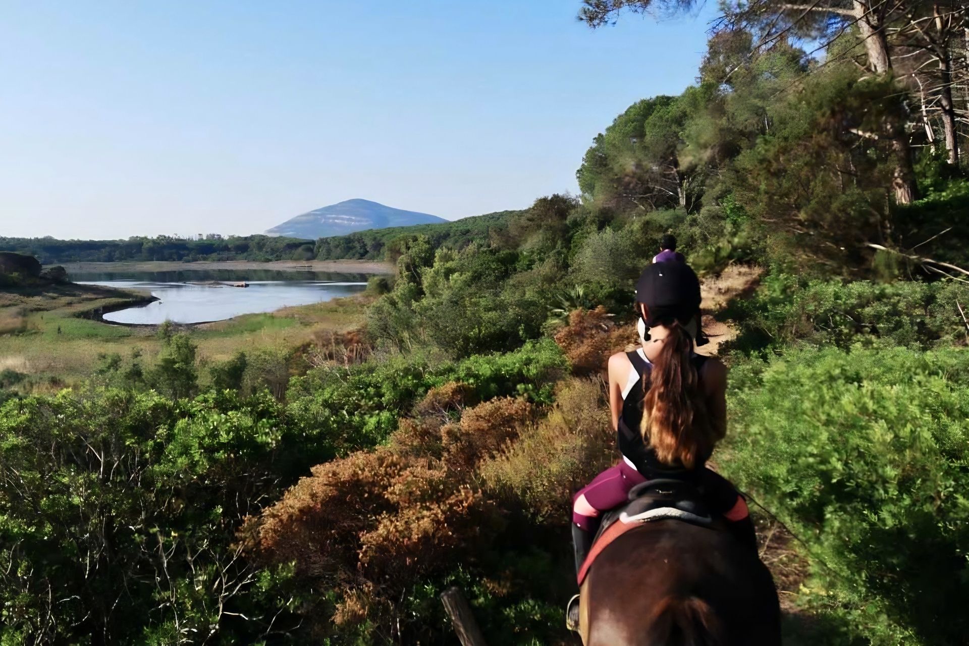 Persone a cavallo entrano al Lago di Baratz