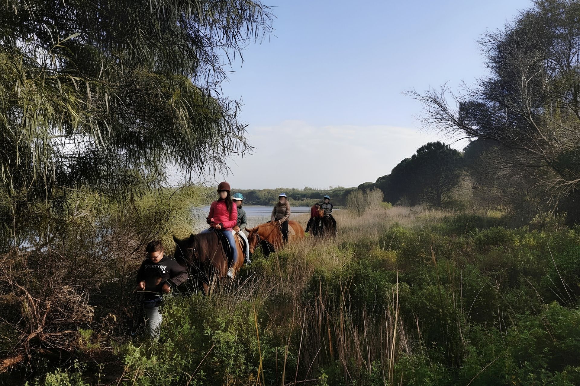 Gruppo di persone a cavallo nel paesaggio del lago di Baratz