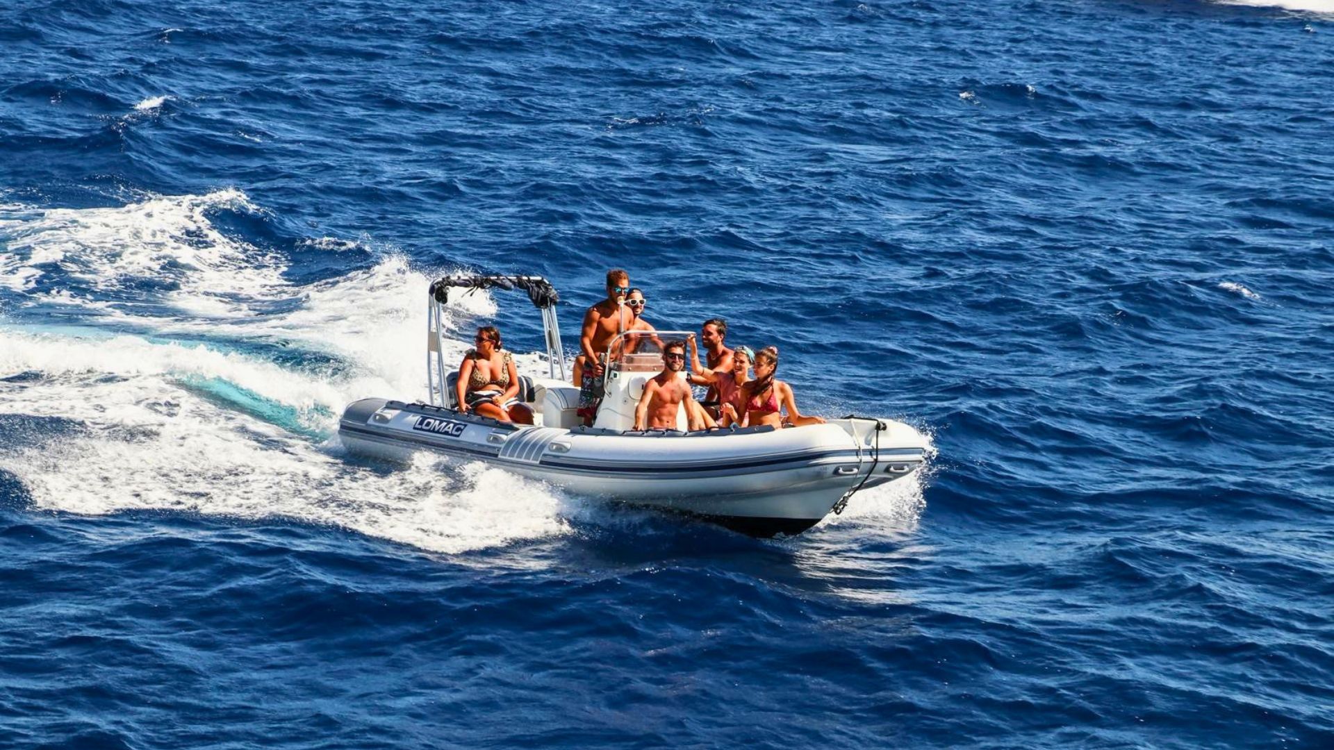 Un gruppo di persone in un gommone sul mare, con un'isola sullo sfondo