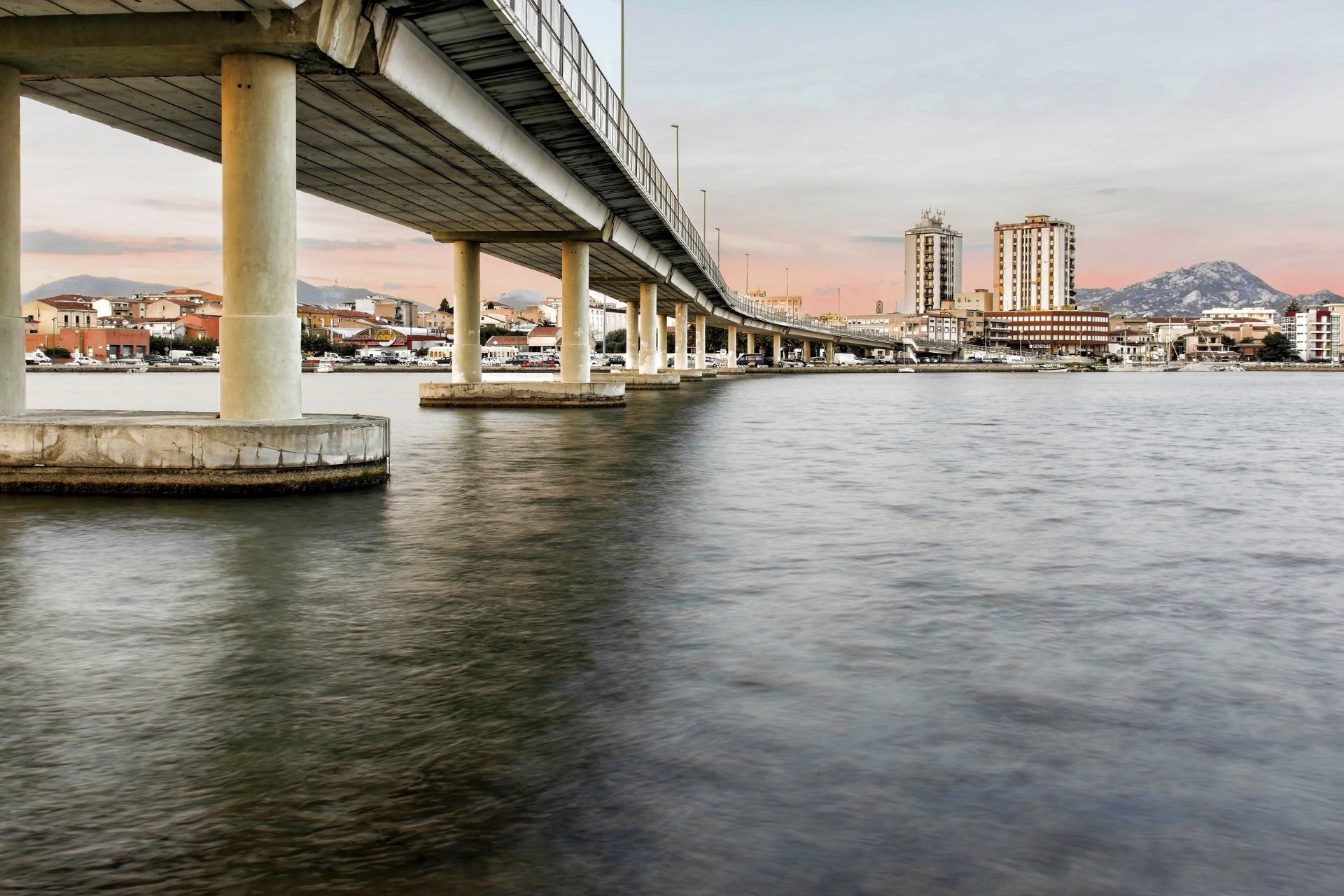Image of a bridge with buildings in the background and surrounding landscape