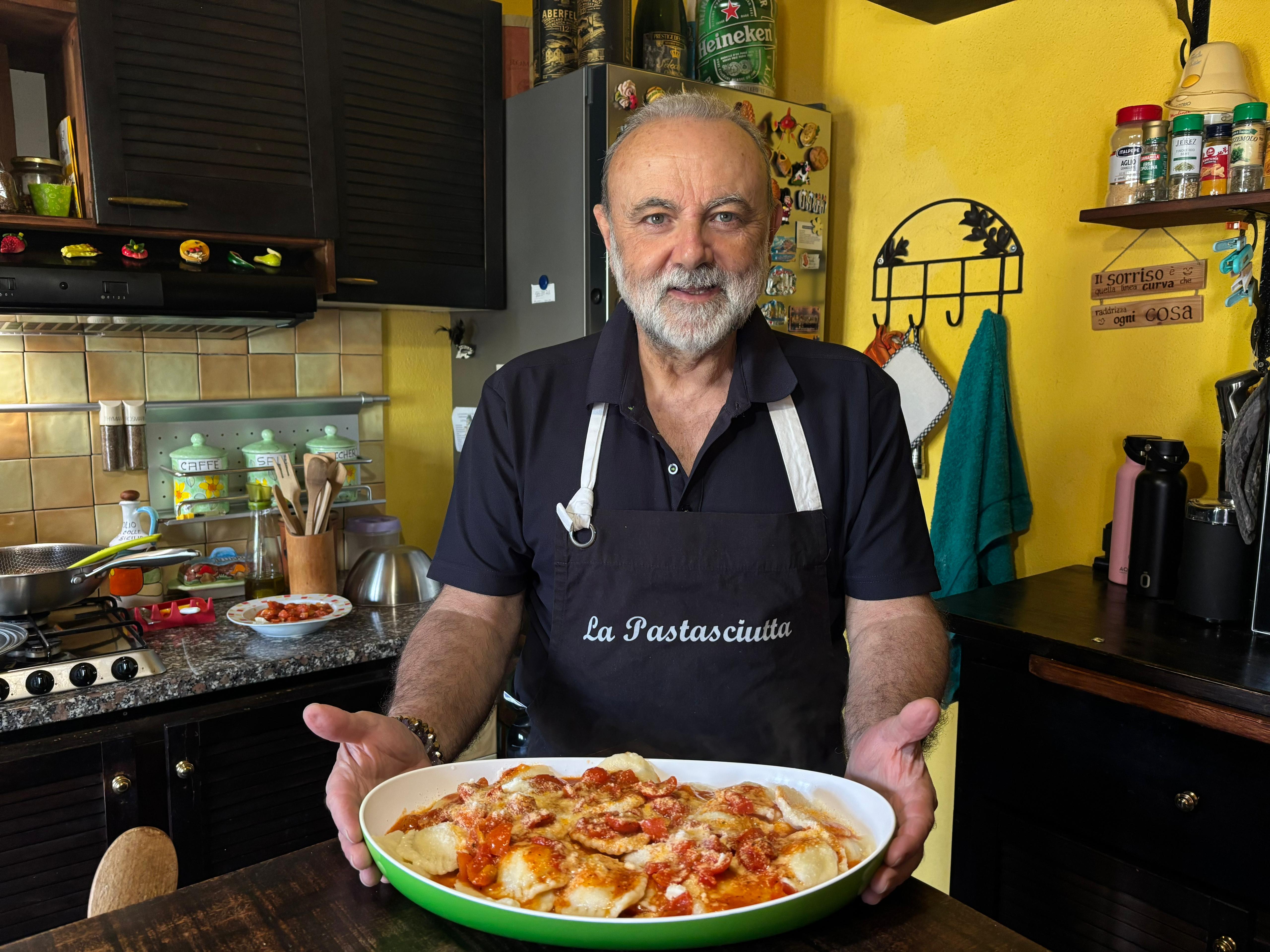 Koch mit einem Teller mit frisch zubereiteten Ravioli