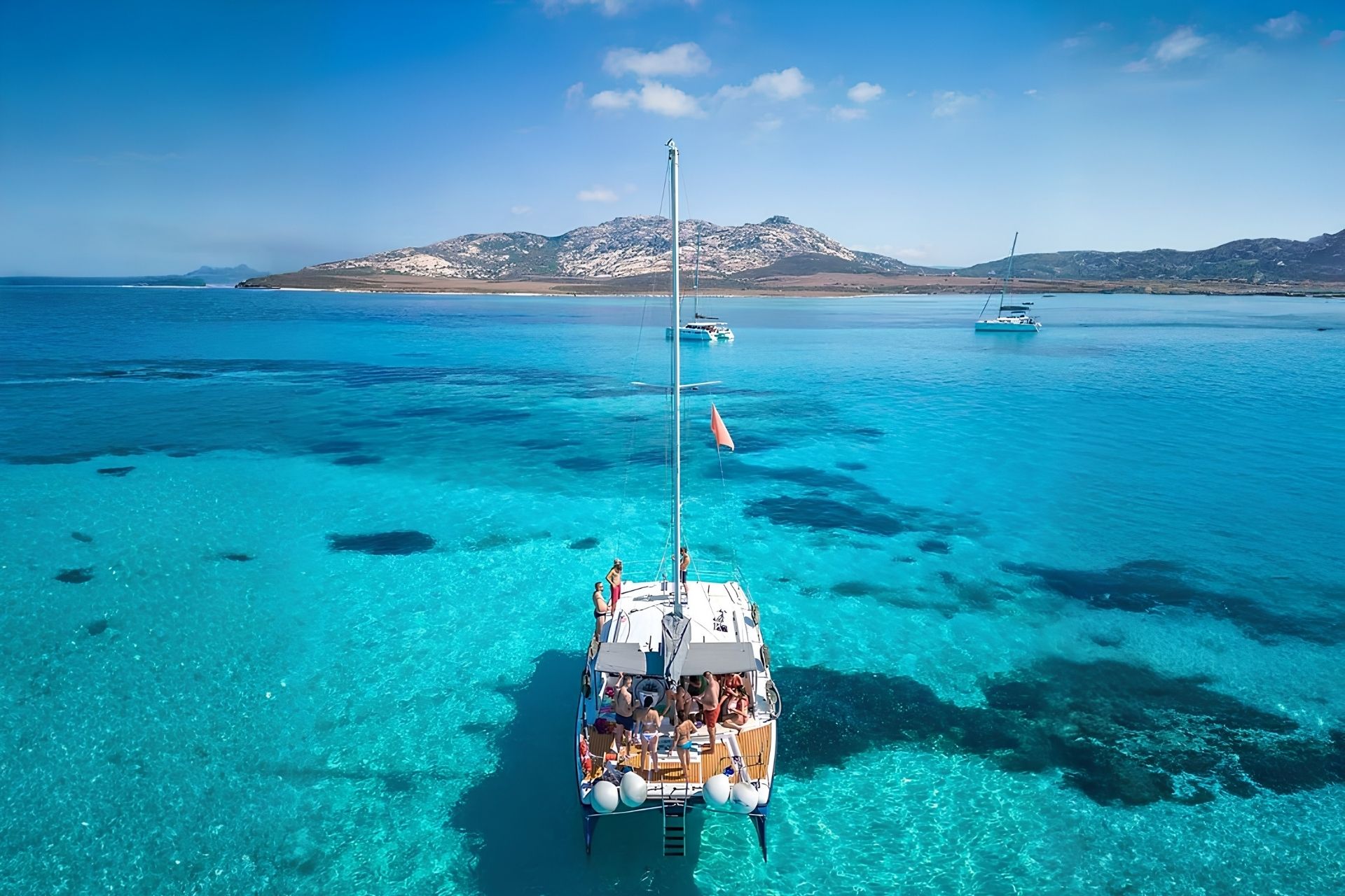 Navegación en catamarán por el Golfo de Asinara, con aguas cristalinas y naturaleza salvaje.