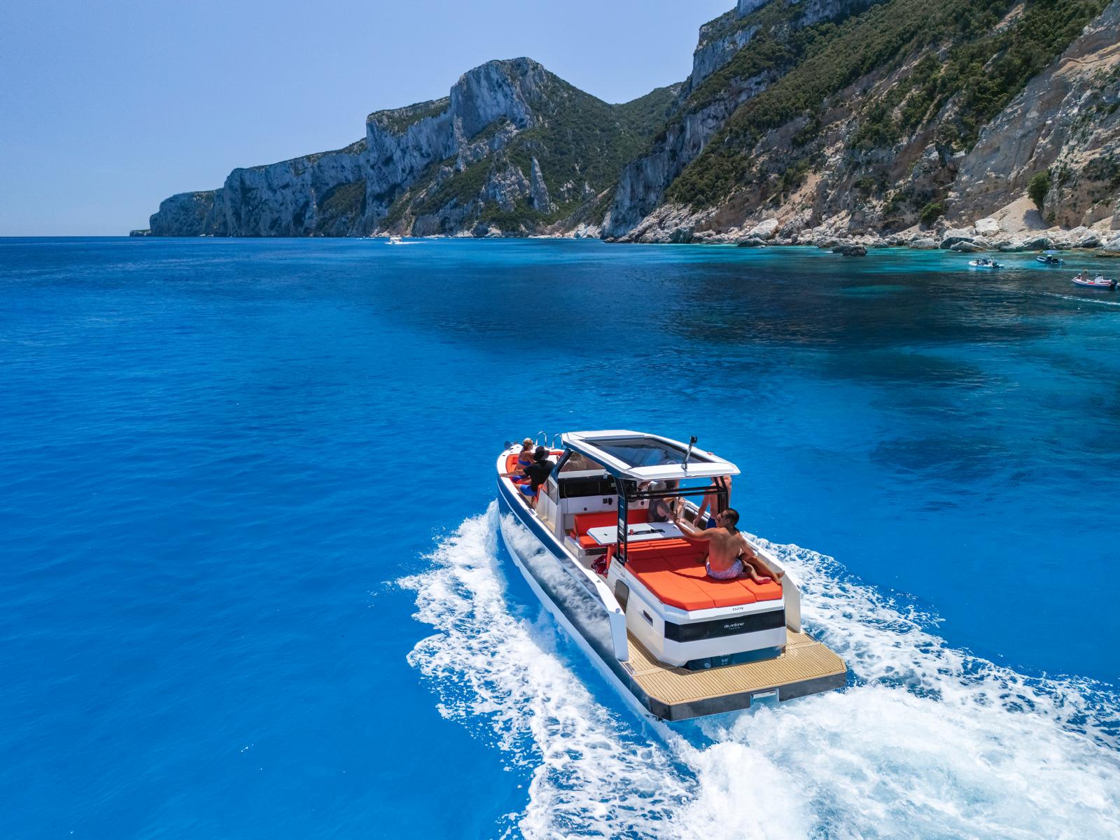 Mini yacht sails between crystal clear turquoise waters and cliffs, with stops at sheltered beaches and snorkeling in sea caves.