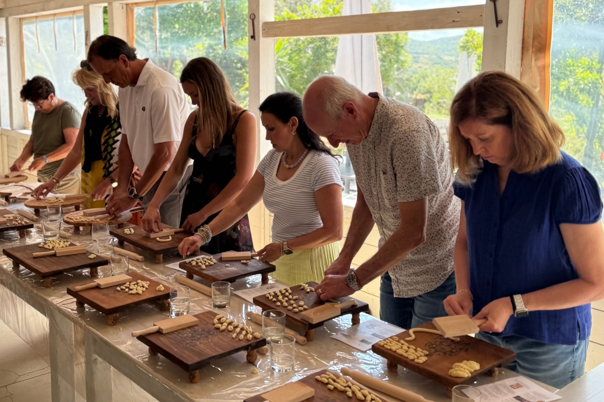 A person prepares fresh pasta by hand during a pasta workshop in Olbia.