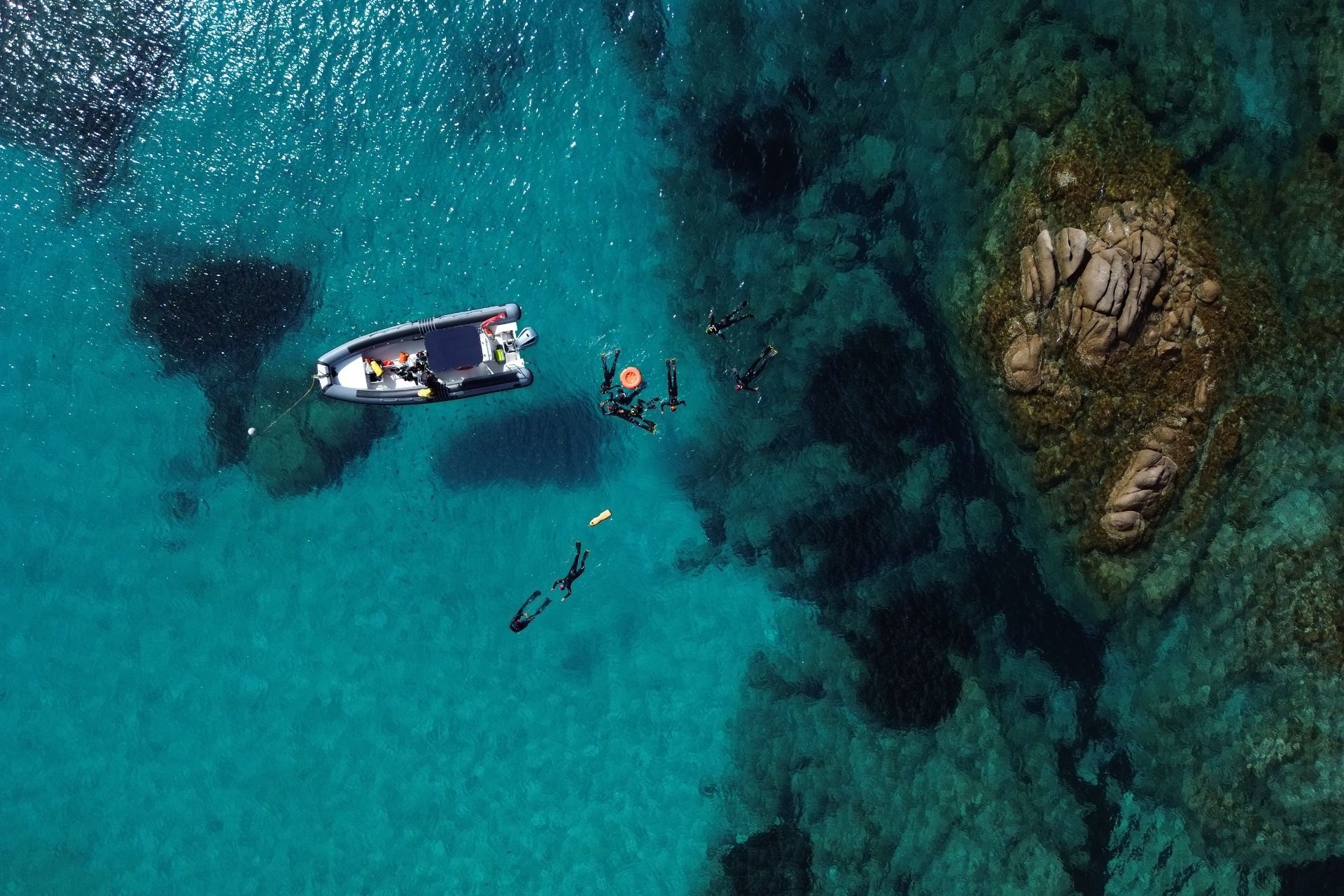 Snorkeling nelle Piscine Naturali di Molara, Sardegna, con fondali colorati e pesciolini che nuotano attorno.