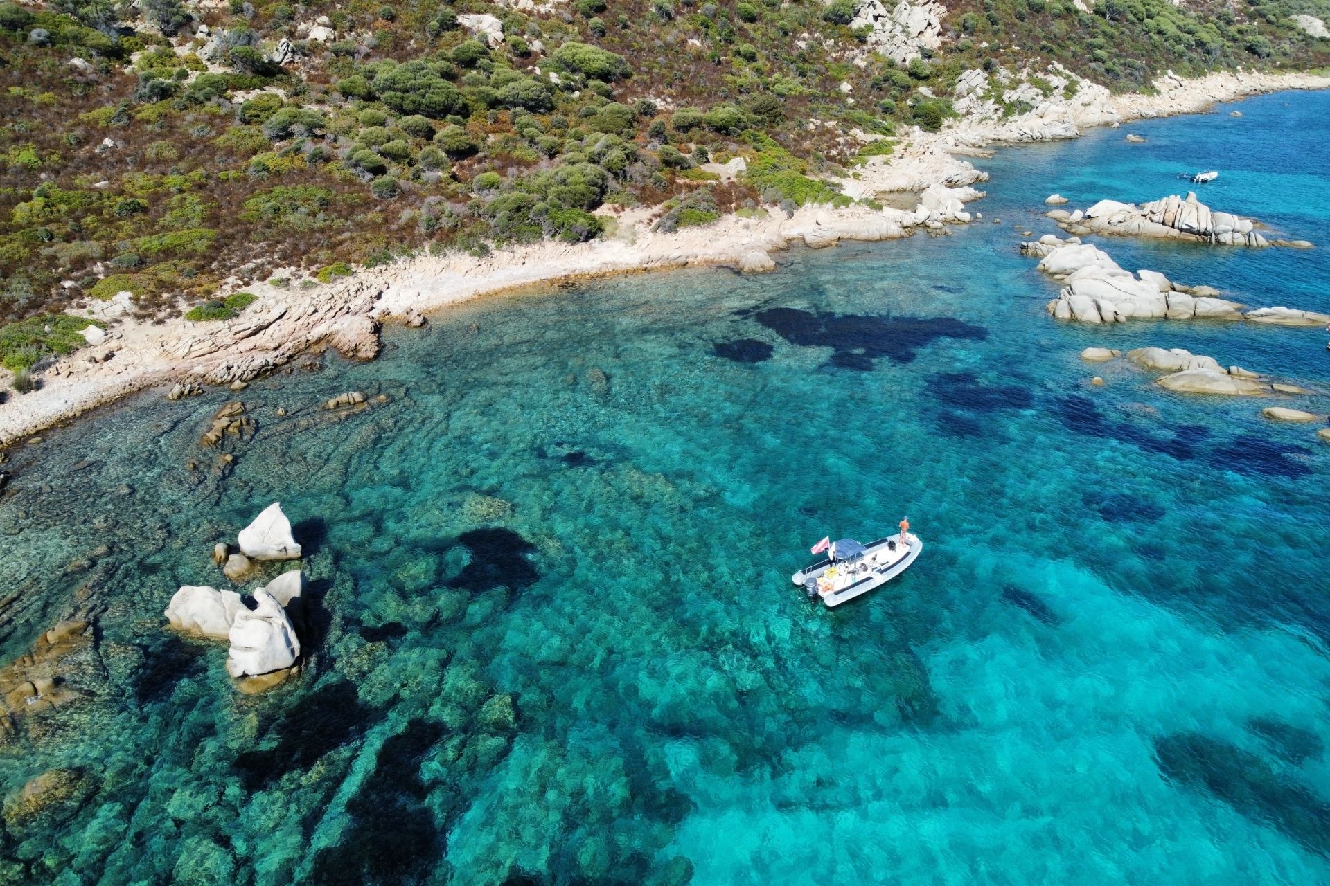 Immagine di un'area marina con acque limpide e rocce, ideale per lo snorkeling e l'esplorazione subacquea.