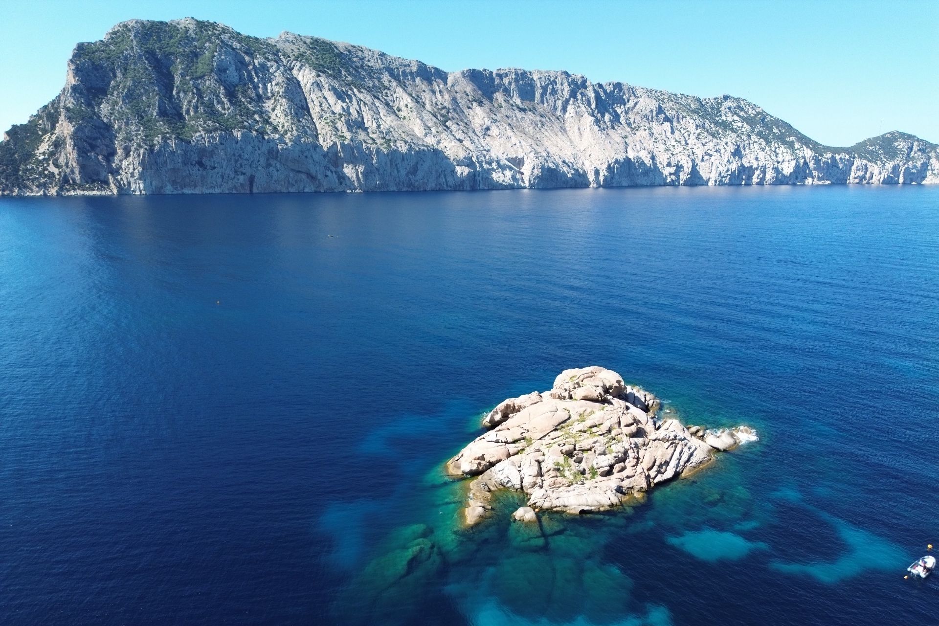 Imagen de una isla con acantilados y mar cristalino, ideal para bucear.