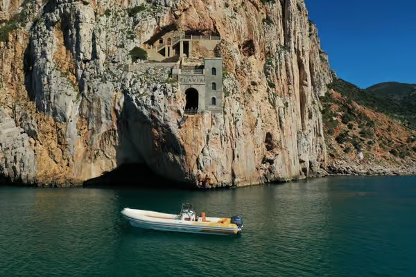 Un gommone naviga lungo la costa sud-ovest della Sardegna, tra natura, archeologia industriale e acque cristalline.