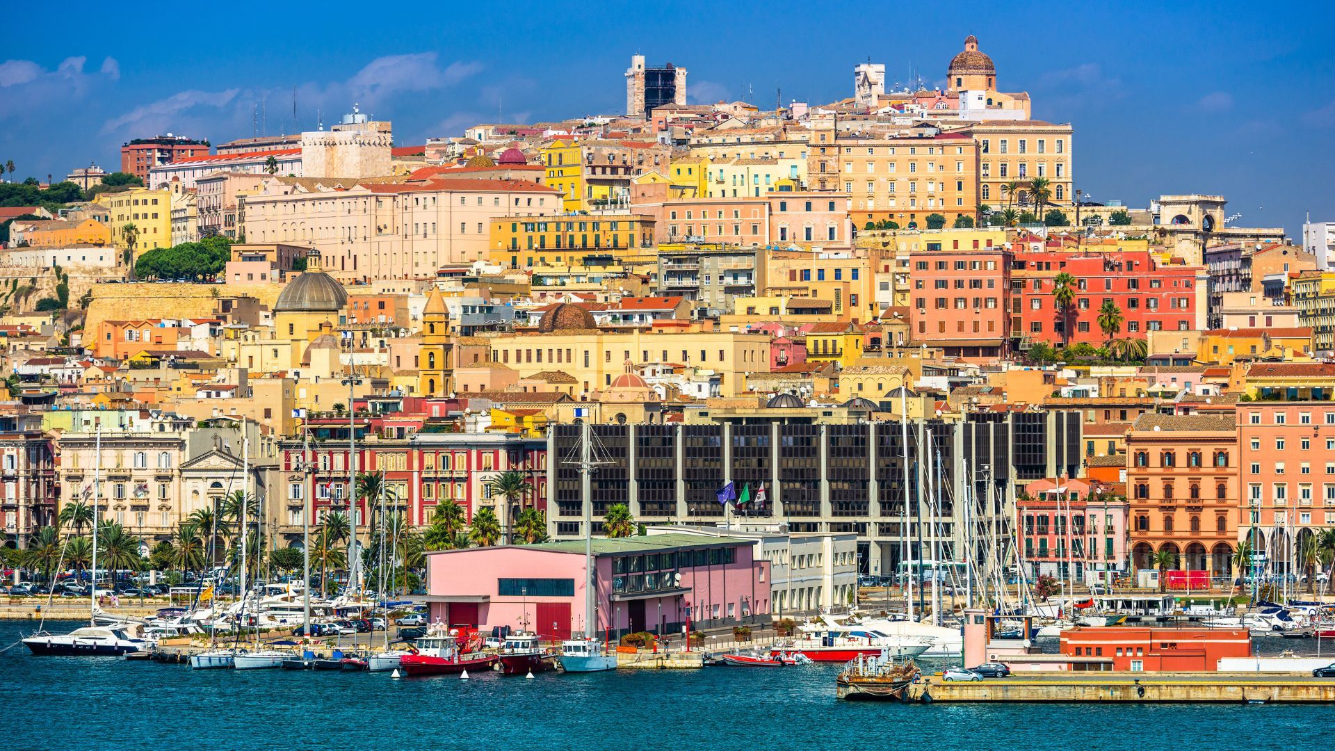 Immagine di un porto con molte barche ormeggiate e edifici colorati in un'area urbana