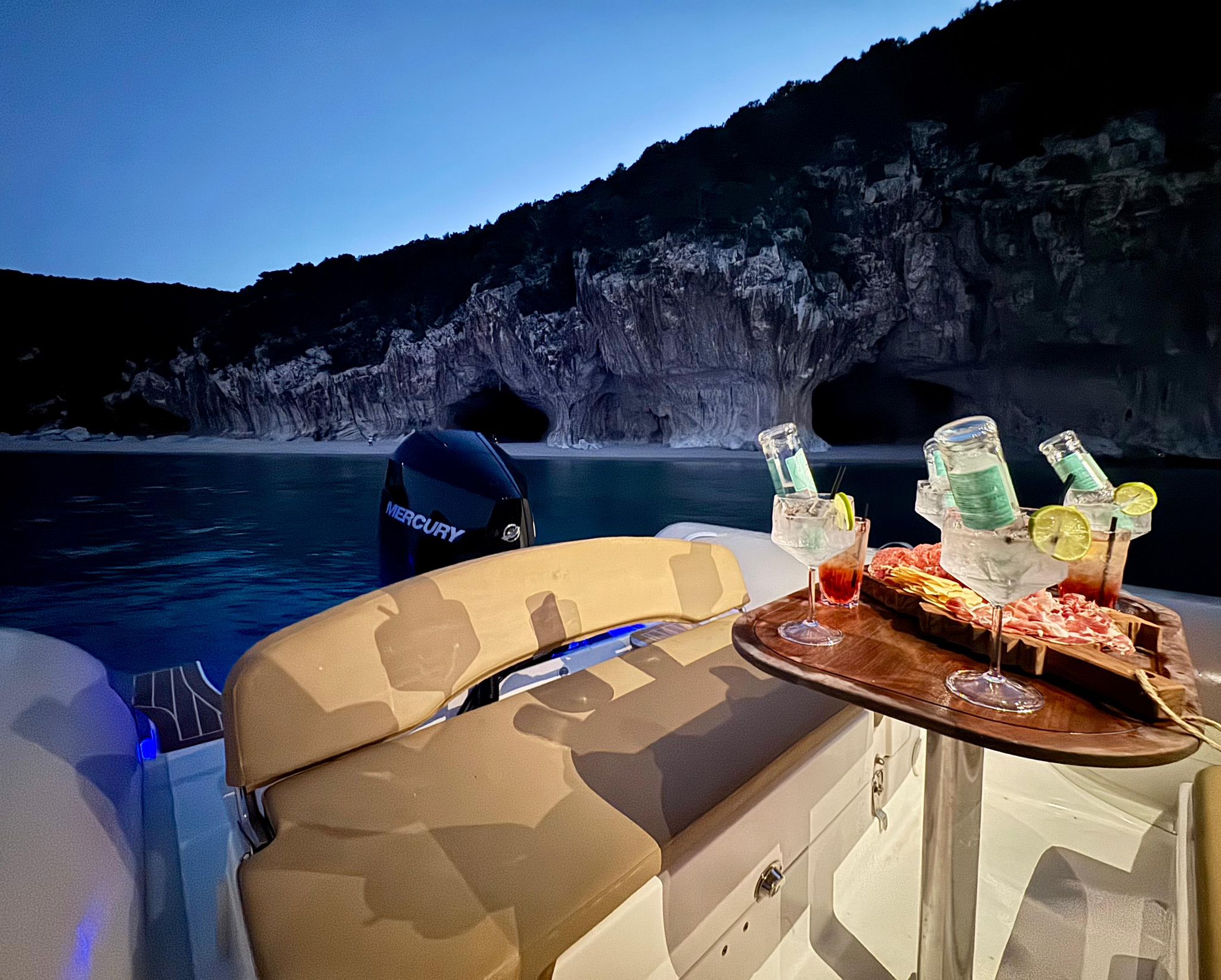 A sailboat with a table and an aperitif with a sea view and a natural cave in the background