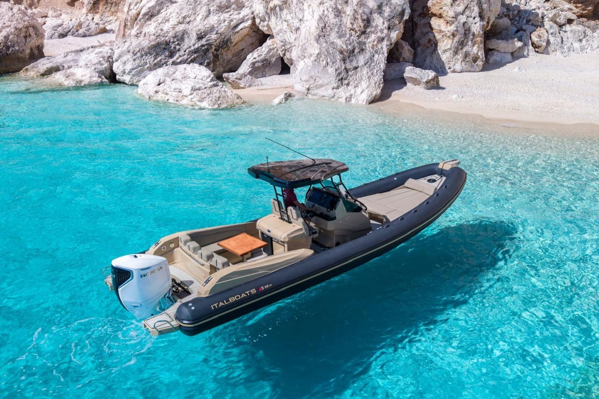 Image d'un canot avec une table et des sièges, dans une eau bleue avec des rochers en arrière-plan.