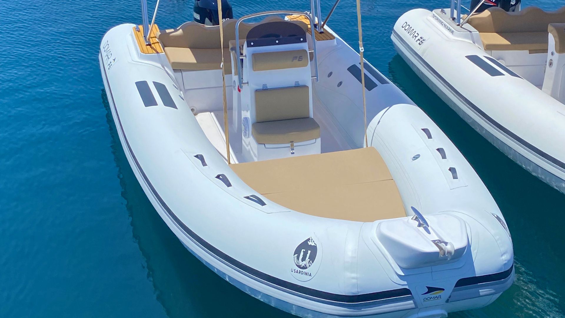 Two white rafts with beige seats moored in water