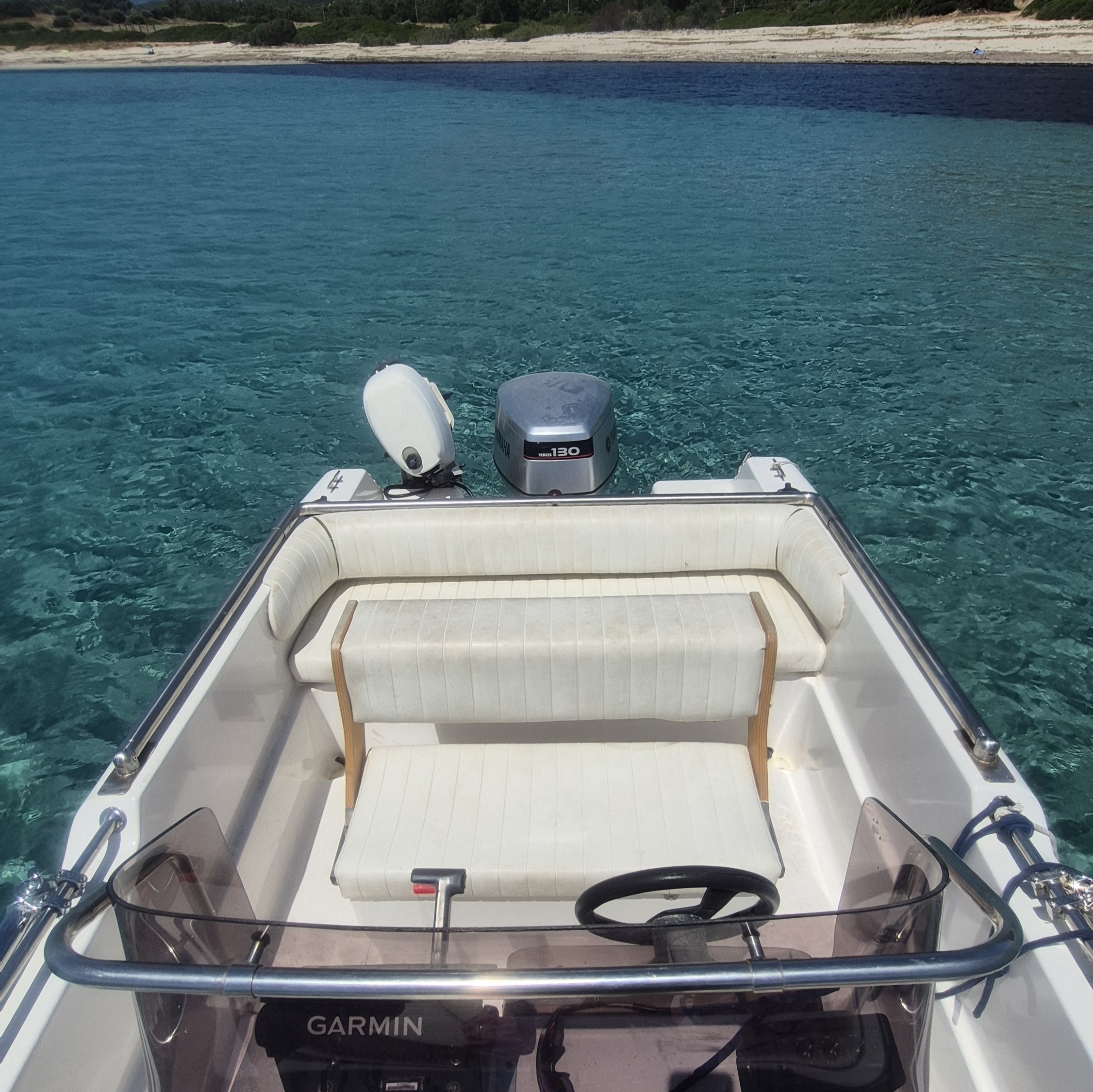 Immagine di una barca con sedili e motori sul mare, ideale per un tour privato in barca a Costa Rei.