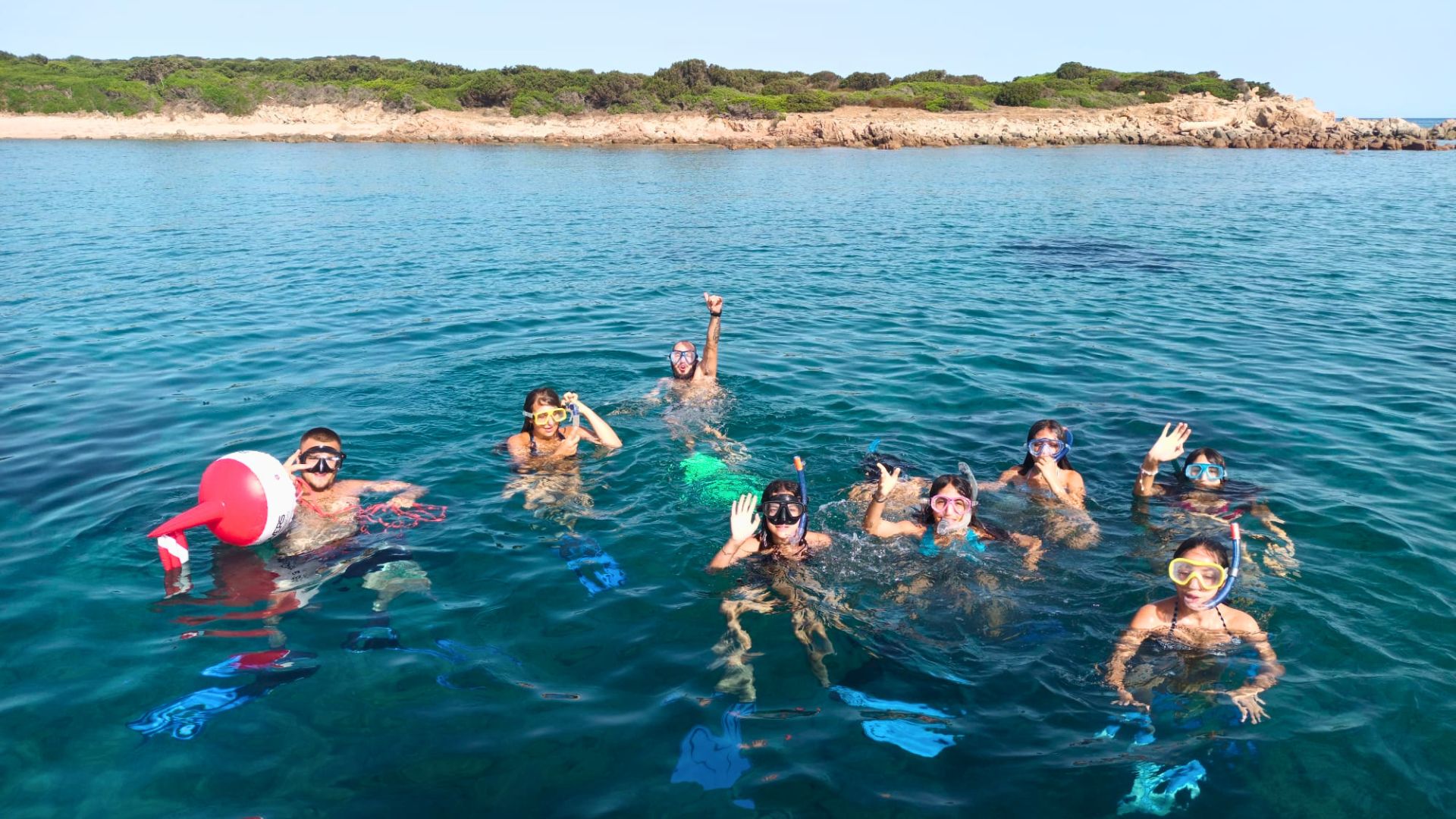 Un grupo de personas sonríe y se divierte buceando en el mar con máscara y tubo