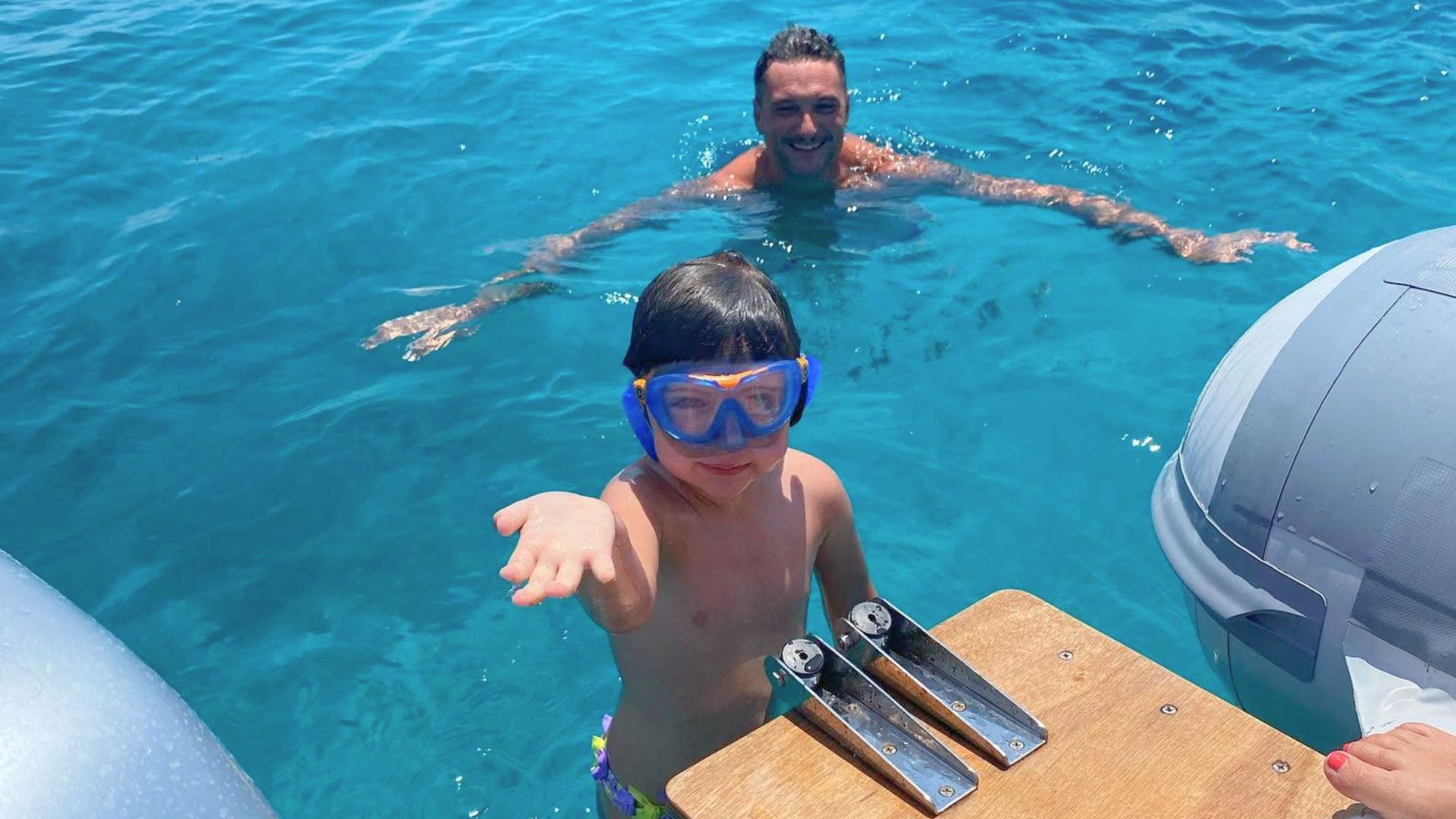 Dos personas, un adulto y un niño, bucean en las cristalinas aguas azules