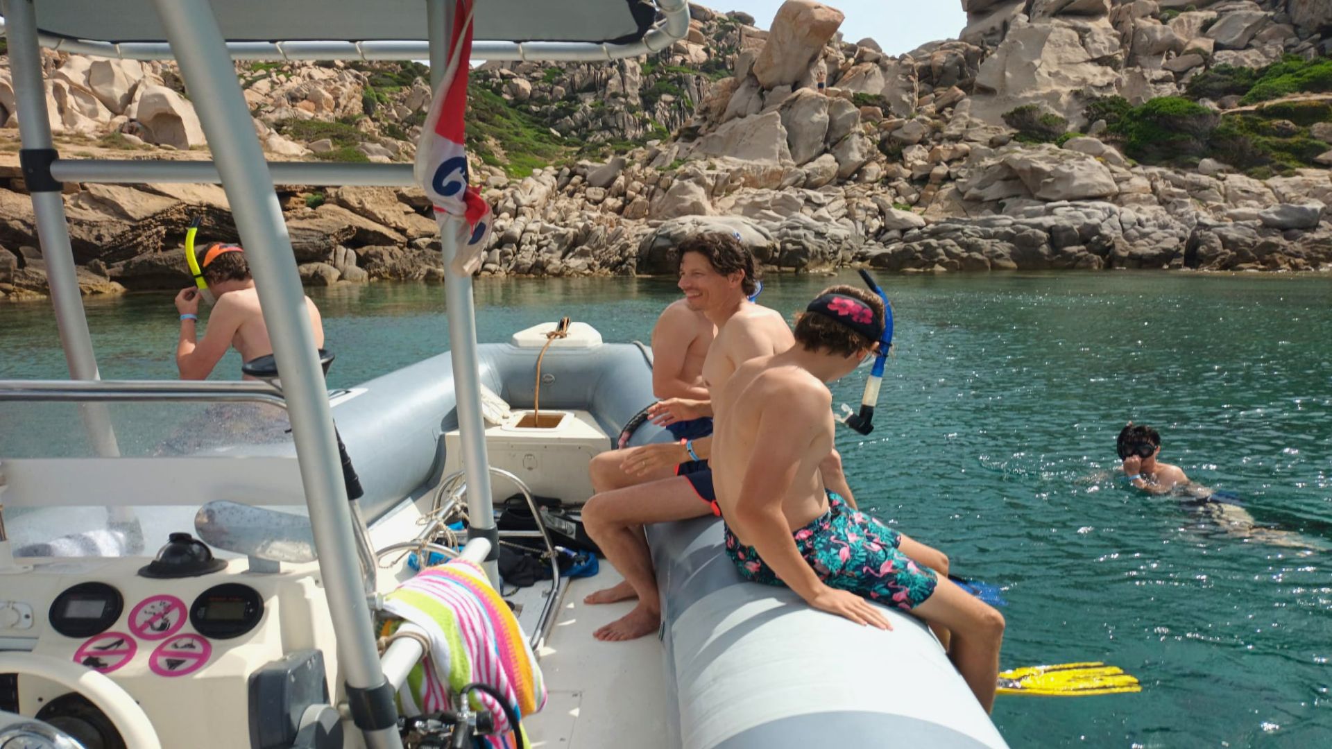 Imagen de un grupo de personas en el agua con equipo de snorkel y un bote en primer plano