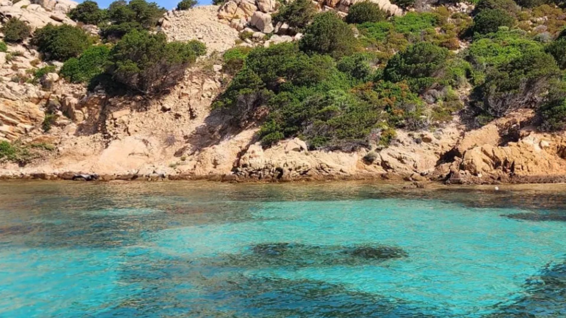 Imagen de un paisaje marino con aguas cristalinas y rocas con vistas al mar