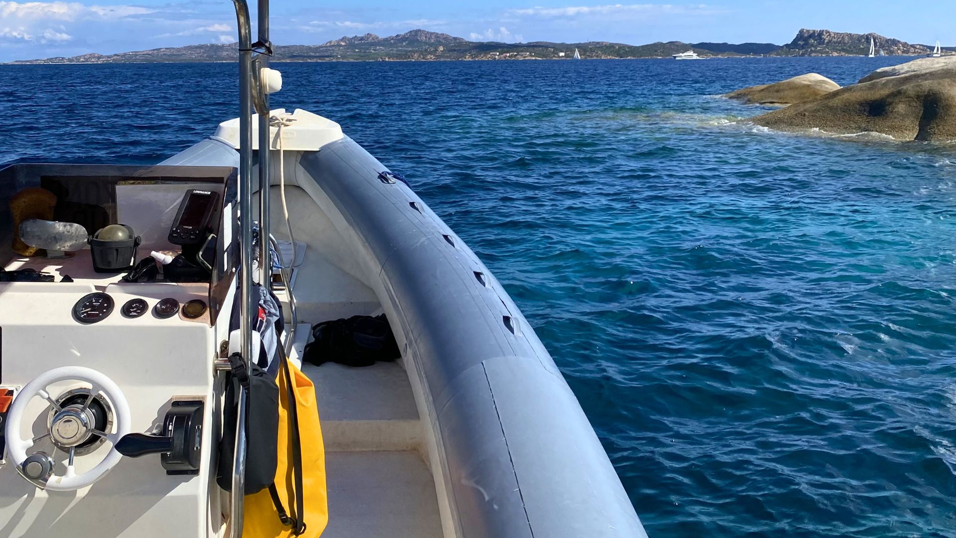 Imagen de un bote con equipo de snorkel y una costa rocosa al fondo