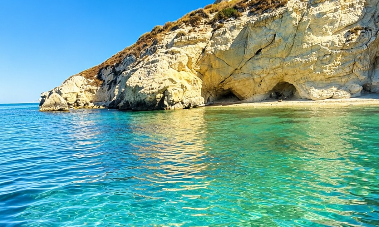 Image d'une côte avec des falaises calcaires et une mer limpide, idéale pour une excursion en bateau avec arrêts et apéritif.